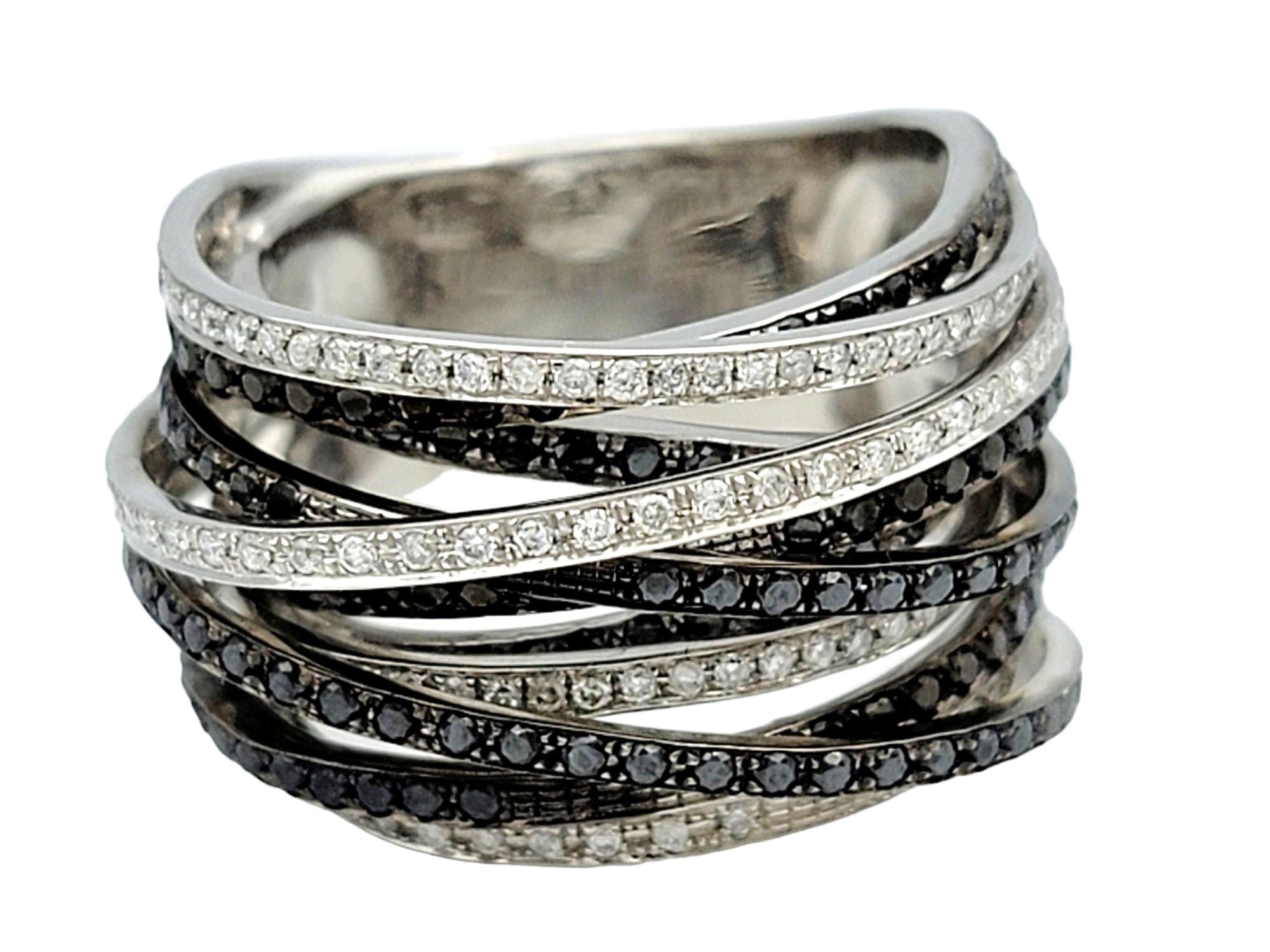 Ring Size: 7.5

Crafted from lustrous 14 karat white gold, this captivating band ring boasts a multi-row design adorned with a stunning array of black and white diamonds. The rows are meticulously layered over one another, creating a sense of depth