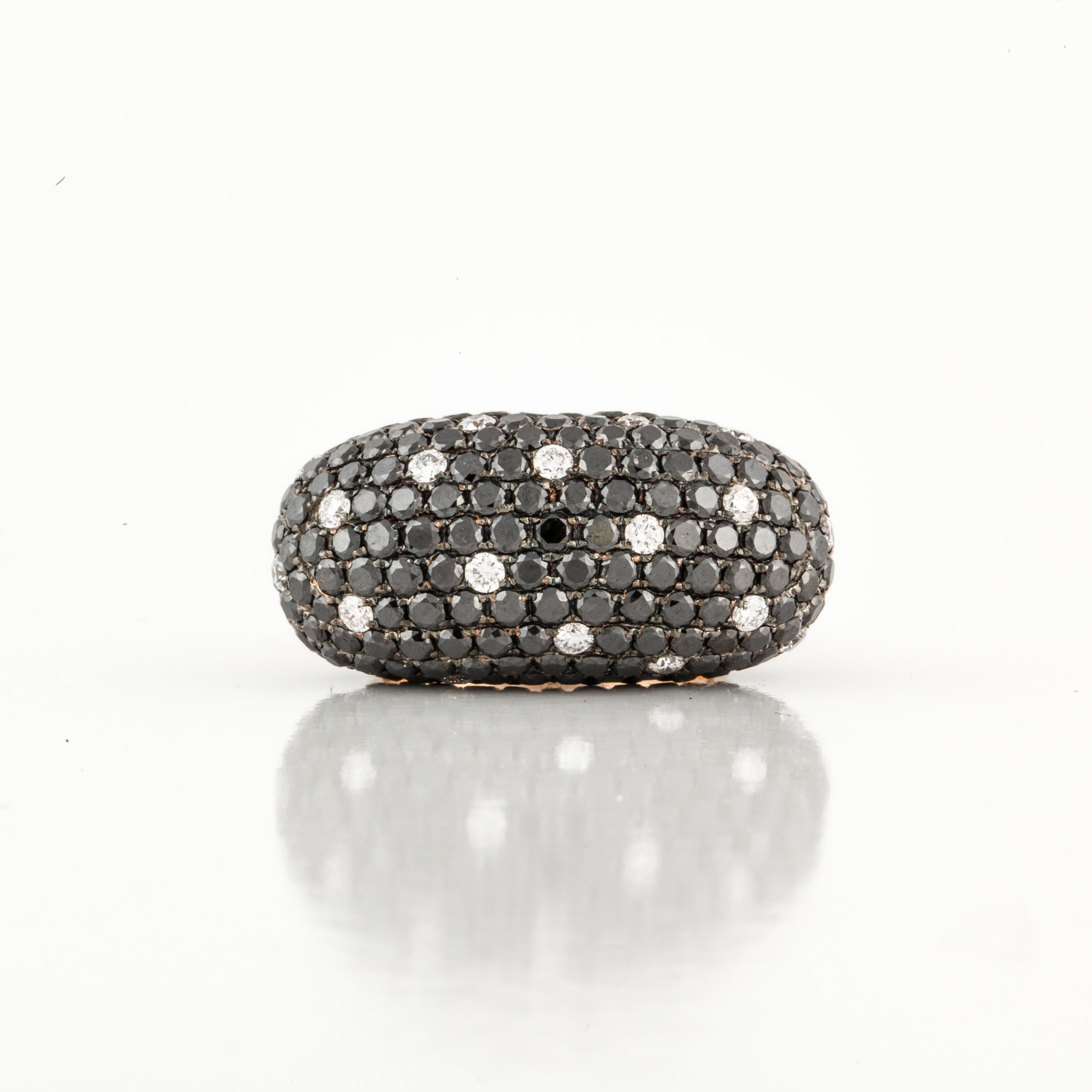 18K rose gold ring with pavé-set black and white diamonds.  There are 26 round diamonds that total 2.10 carats; G-H color and VS1-2 clarity.  There are also 208 round black diamonds that total 7 carats.   Total carat weight is 9.10 carats. 