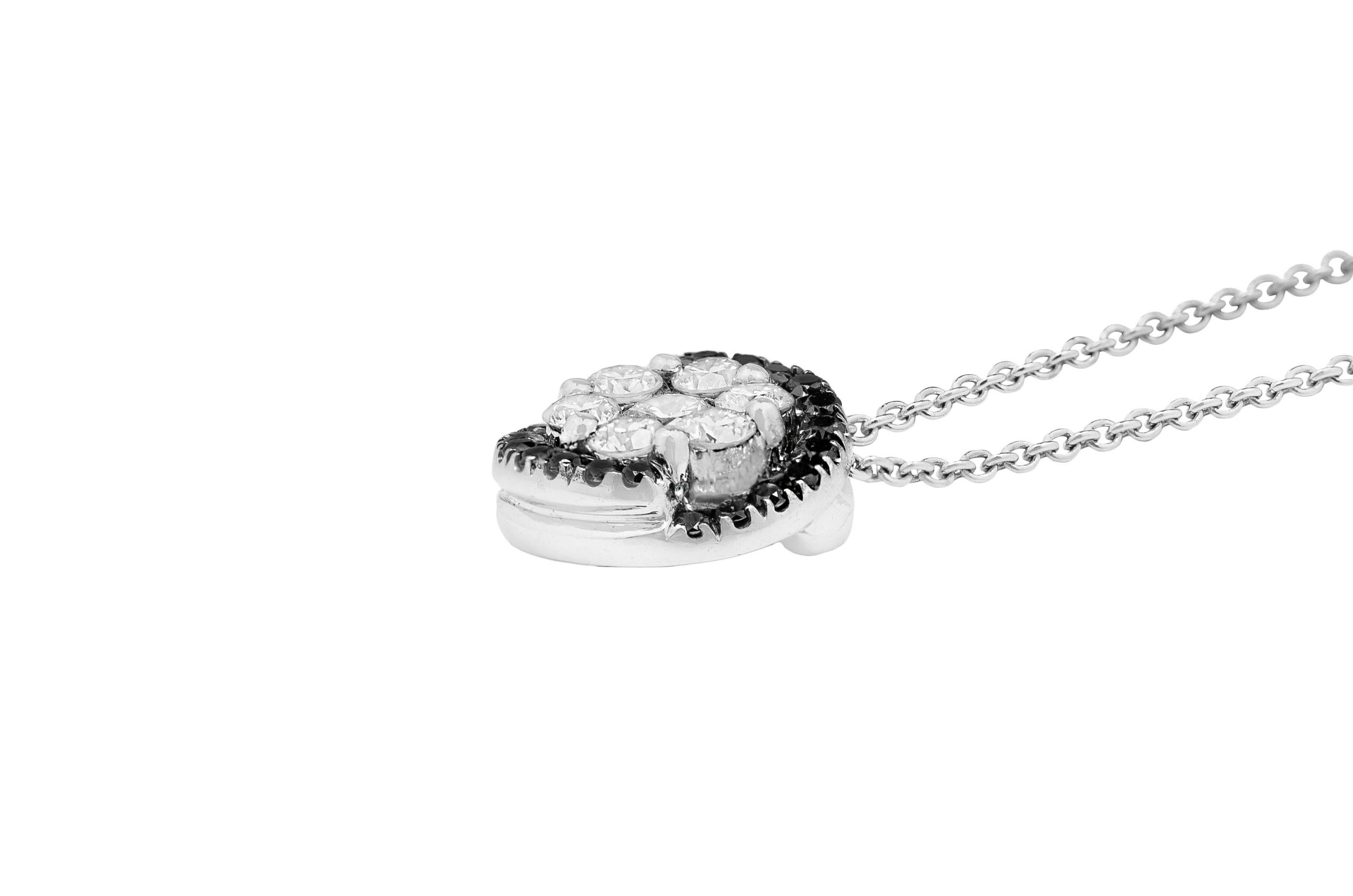 This modern white gold necklace is made in Italy by Fanuele Gioielli. 
Made entirely of 18k white gold it features a pendant composed by seven brilliant cut white diamonds surrounded by a row of brilliant cut black diamonds.

Black diamonds total