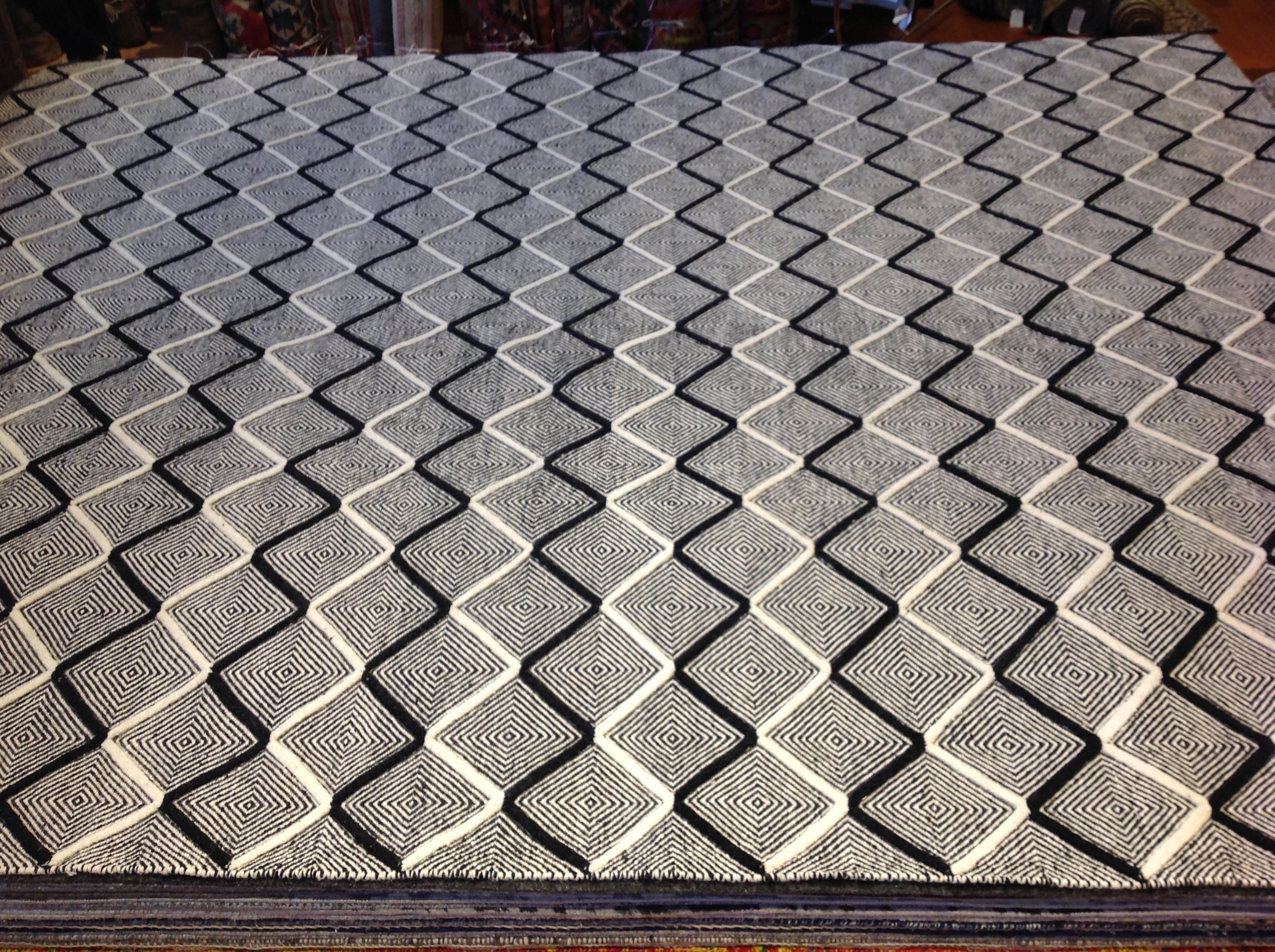 A black and white variation of a very popular design. Contrasting colors, geometric design, high low construction, this is a rug that brings together vibrancy and texture in the most dynamic and exciting way. Wool. Hand knotted in India.
