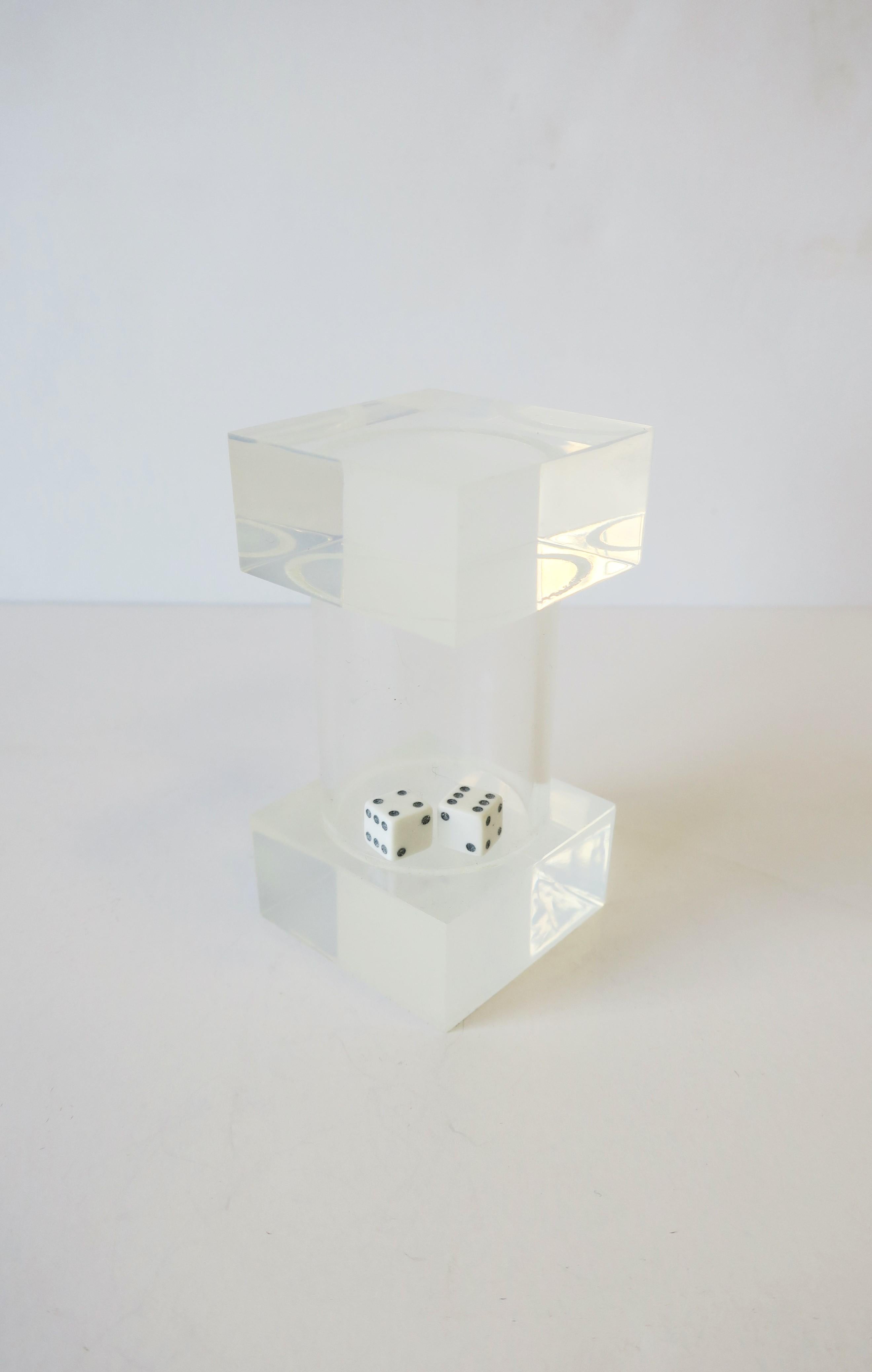 A Lucite dice Shaker the Modern style or Postmodern period. A pair of black and white dice encased in a cylindrical Lucite tube with square Lucite block ends. Item can be used for card games, as a decorative piece, desk accessory, etc.

  