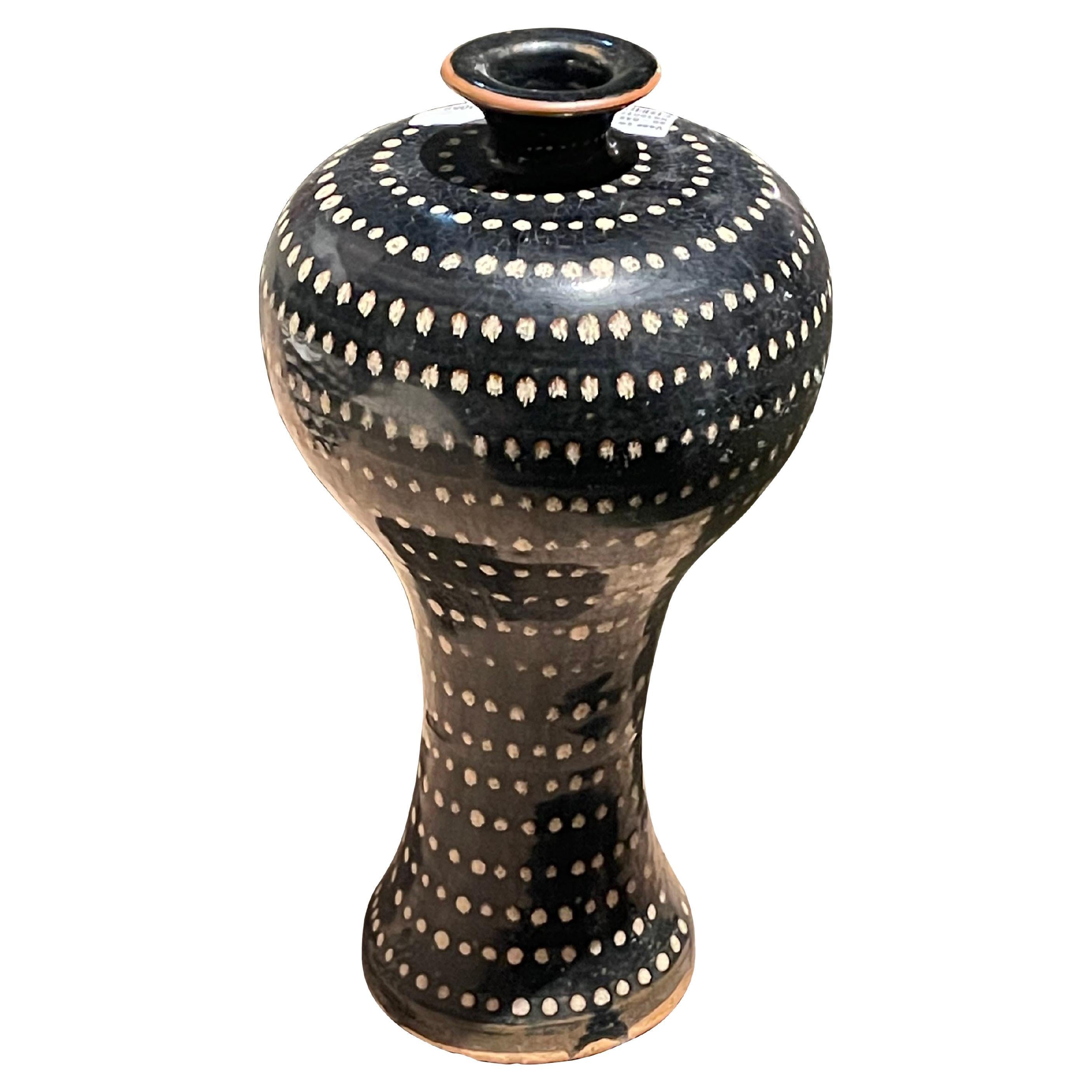 Contemporary Chinese black ground vase with hand painted small white dots.
Curved top shape.
