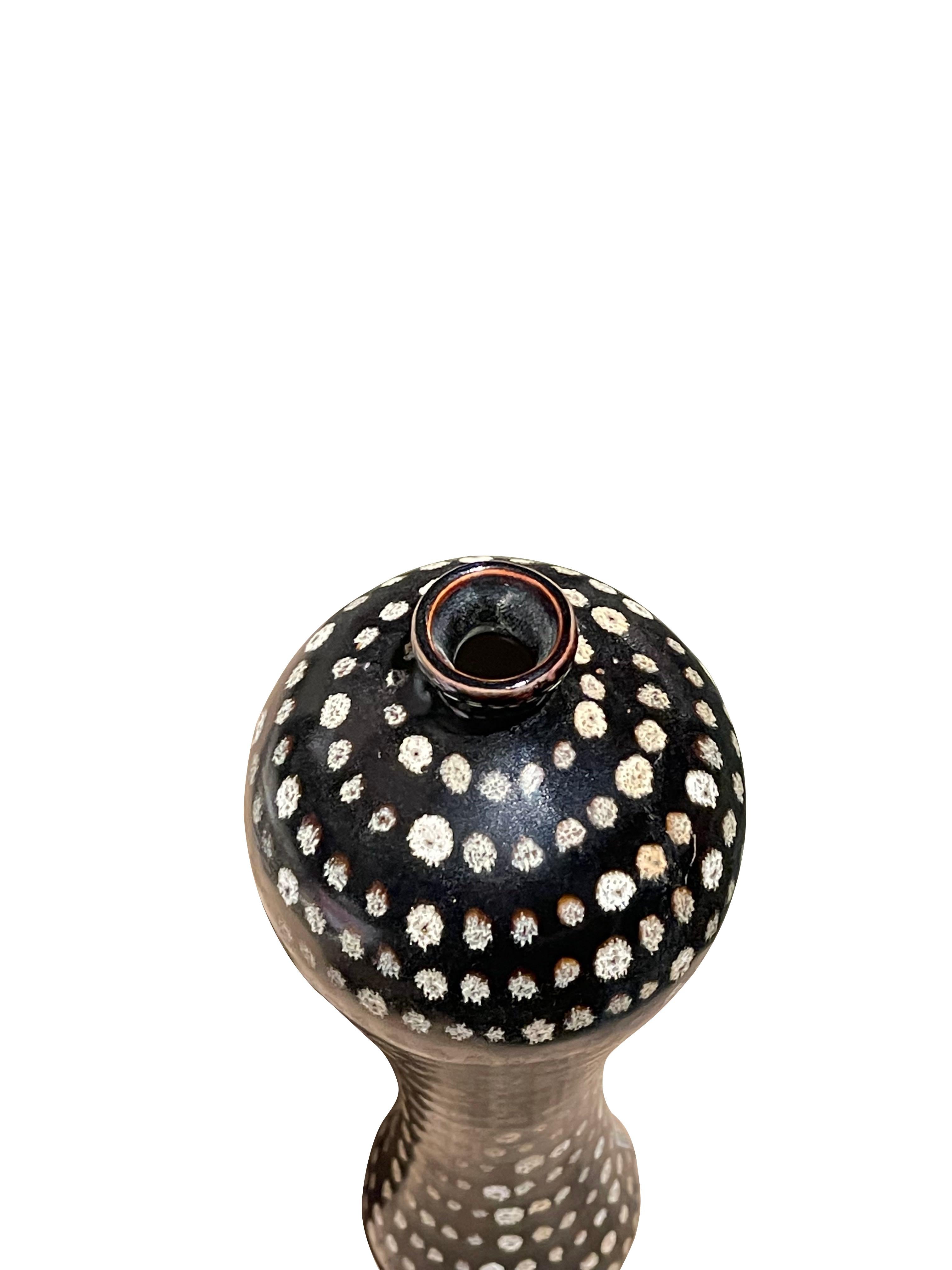 Contemporary Chinese black ground tall, slender, vase with hand painted small white dots.
ARRIVING TBD.