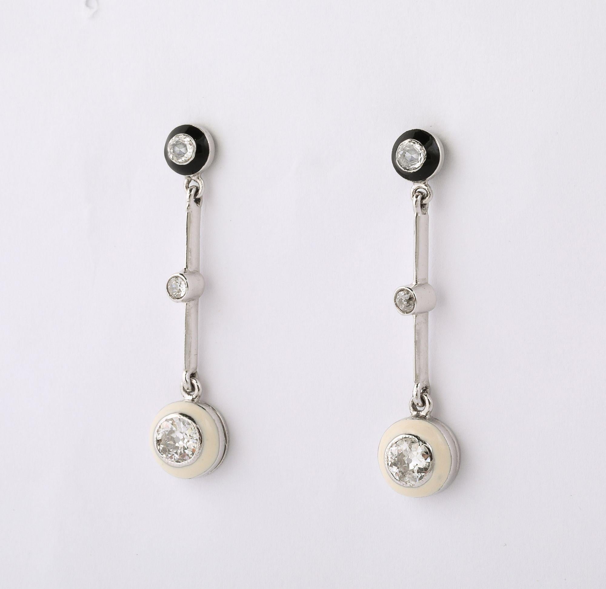 Questi squisiti orecchini a goccia sono un perfetto esempio dello stile elegante e grafico del periodo Art Déco. Realizzati in platino scintillante, presentano un contrasto dinamico di smalto bianco e nero lucido, un segno distintivo dell'estetica
