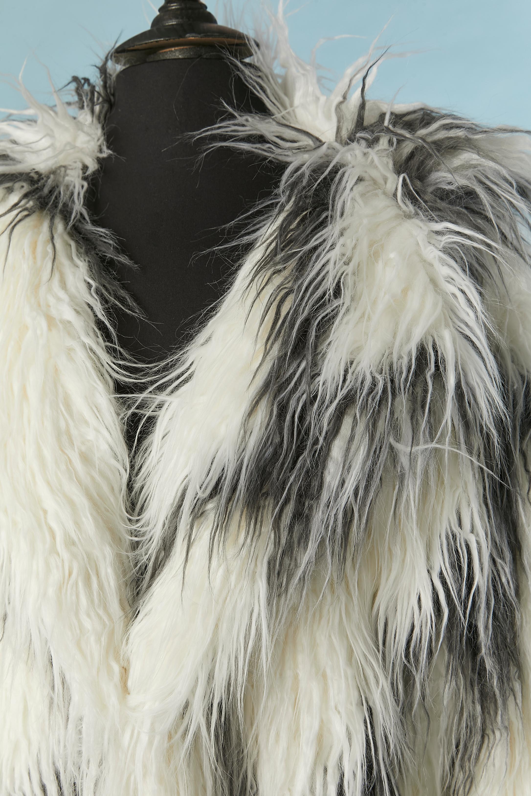 Black and white Faux fur single breasted coat. White lining probably in acetate ( no fabric composition tag) 
3 hook&eye closure in the middle front and pockets on both side. 
Size L 