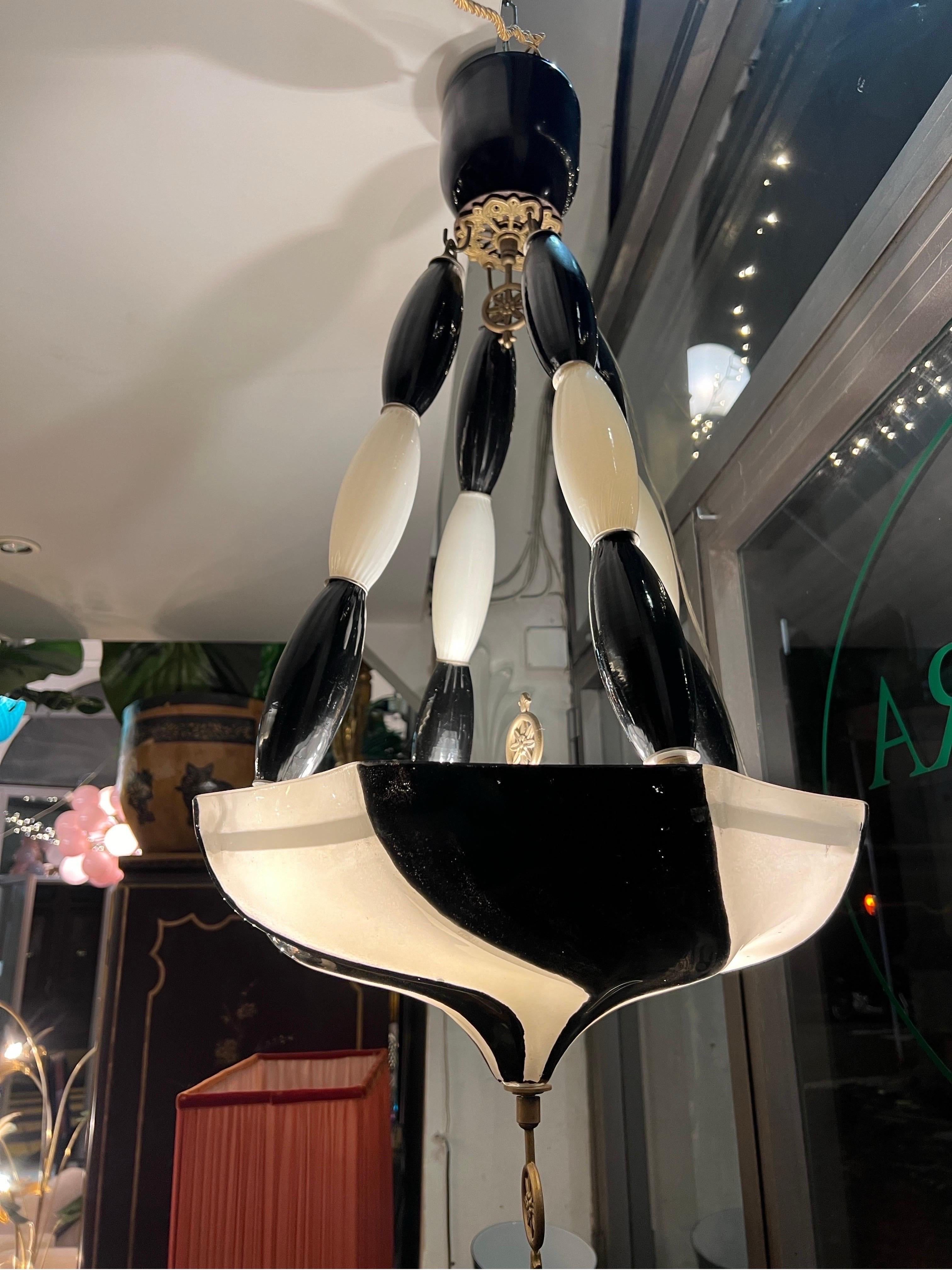 Black and White Fortuny Murano Glass and Bronze Chandelier, torchon effect characterized by oriental atmospheres.
Four light bulbs.