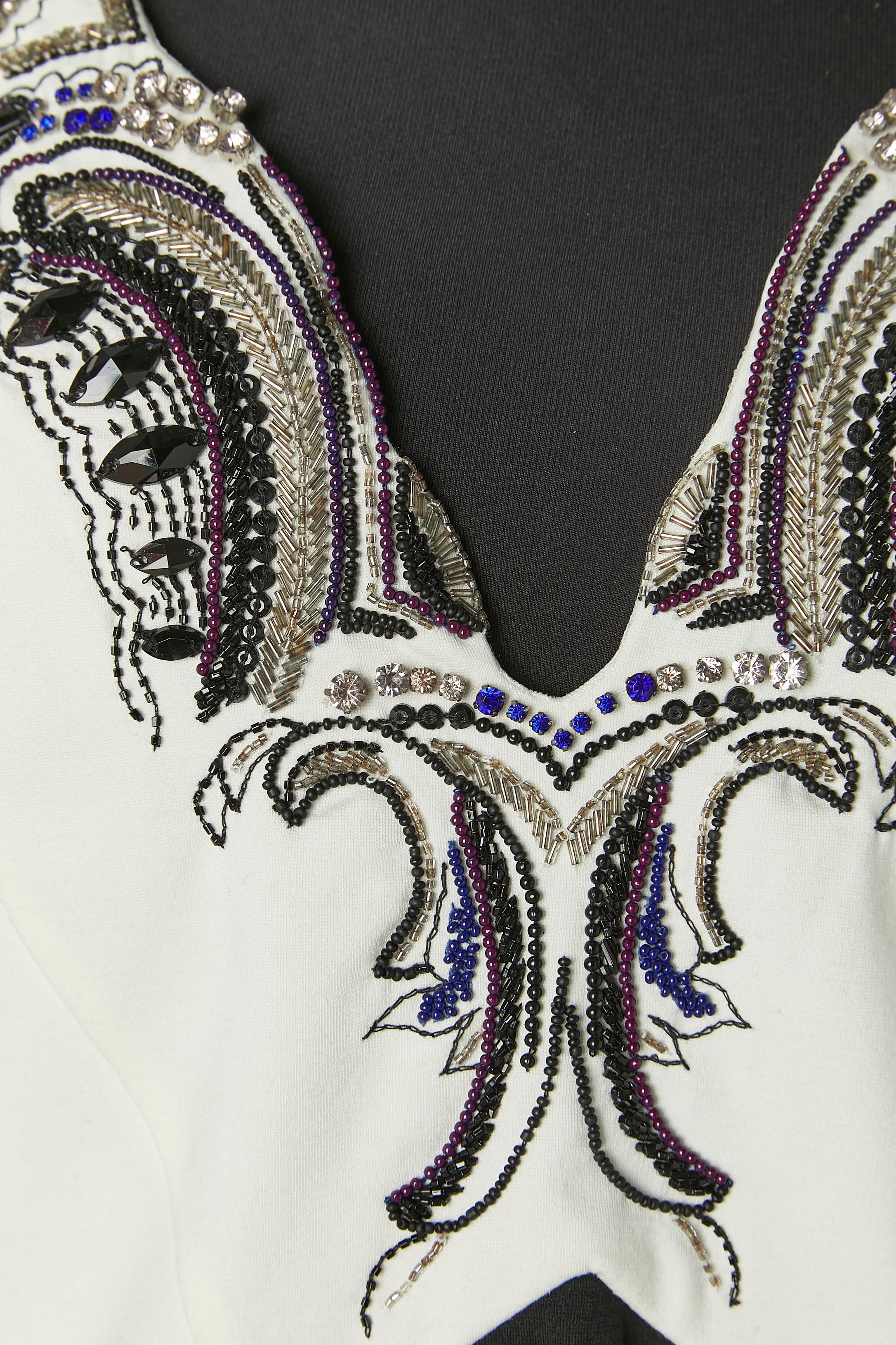 Schwarz-weißes Jerseykleid mit Strassverzierung und Perlenstickerei. 
Zusammensetzung des Stoffes: 57% Viskose, 35% Nylon, 8% Elasthan . Zusammensetzung des Futters: 100% Nylon. Echtheitshologramm.
Reißverschluss und Haken-Ösen-Verschluss in der