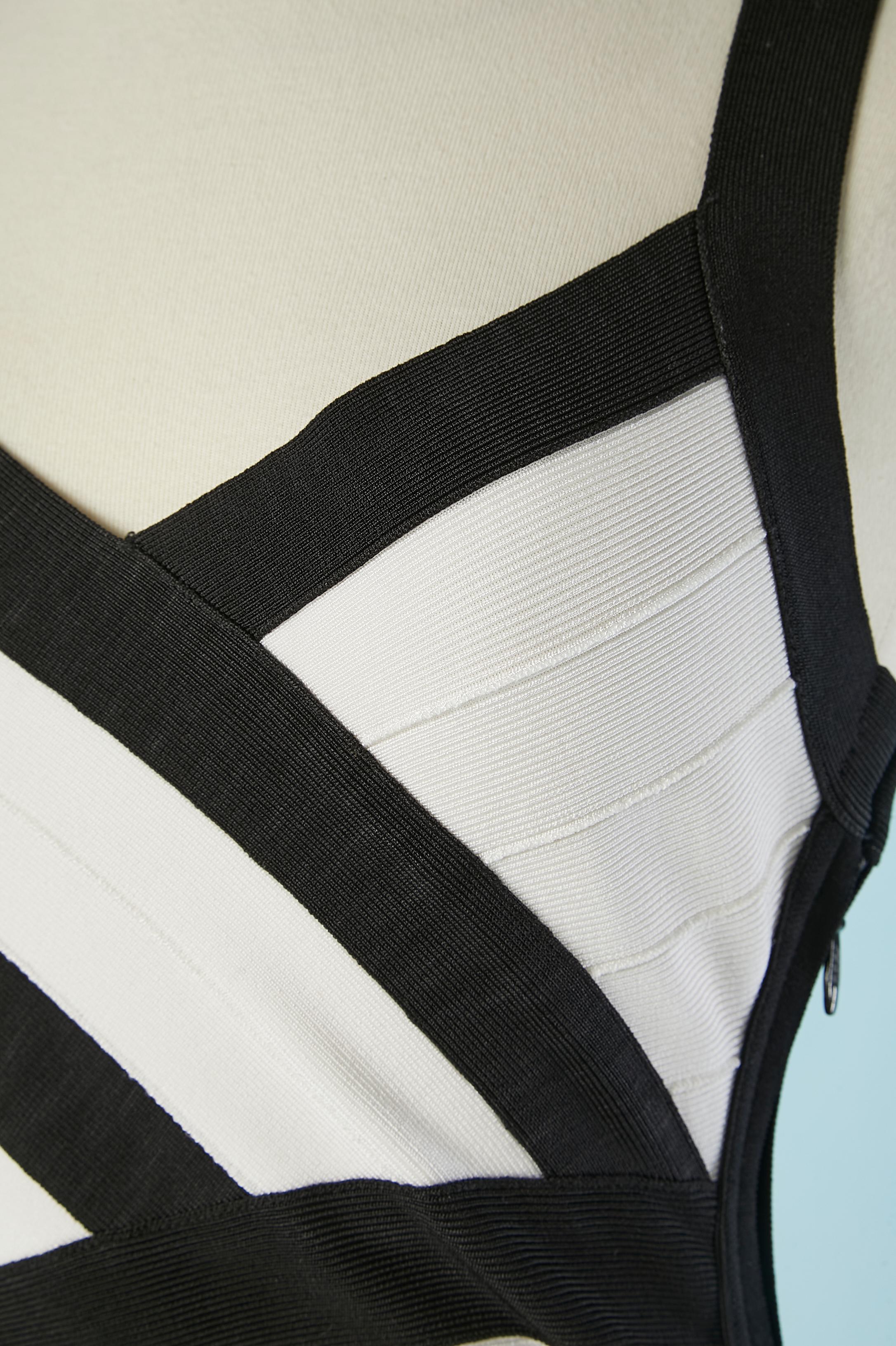 Robe de cocktail en rayonne tricotée noire et blanche. Composition du tissu : 90% rayonne, 9% nylon, 1% spandex. 
Fermeture éclair sur le côté gauche + 3 crochets. 
Taille M sur l'étiquette mais taille plutôt XS