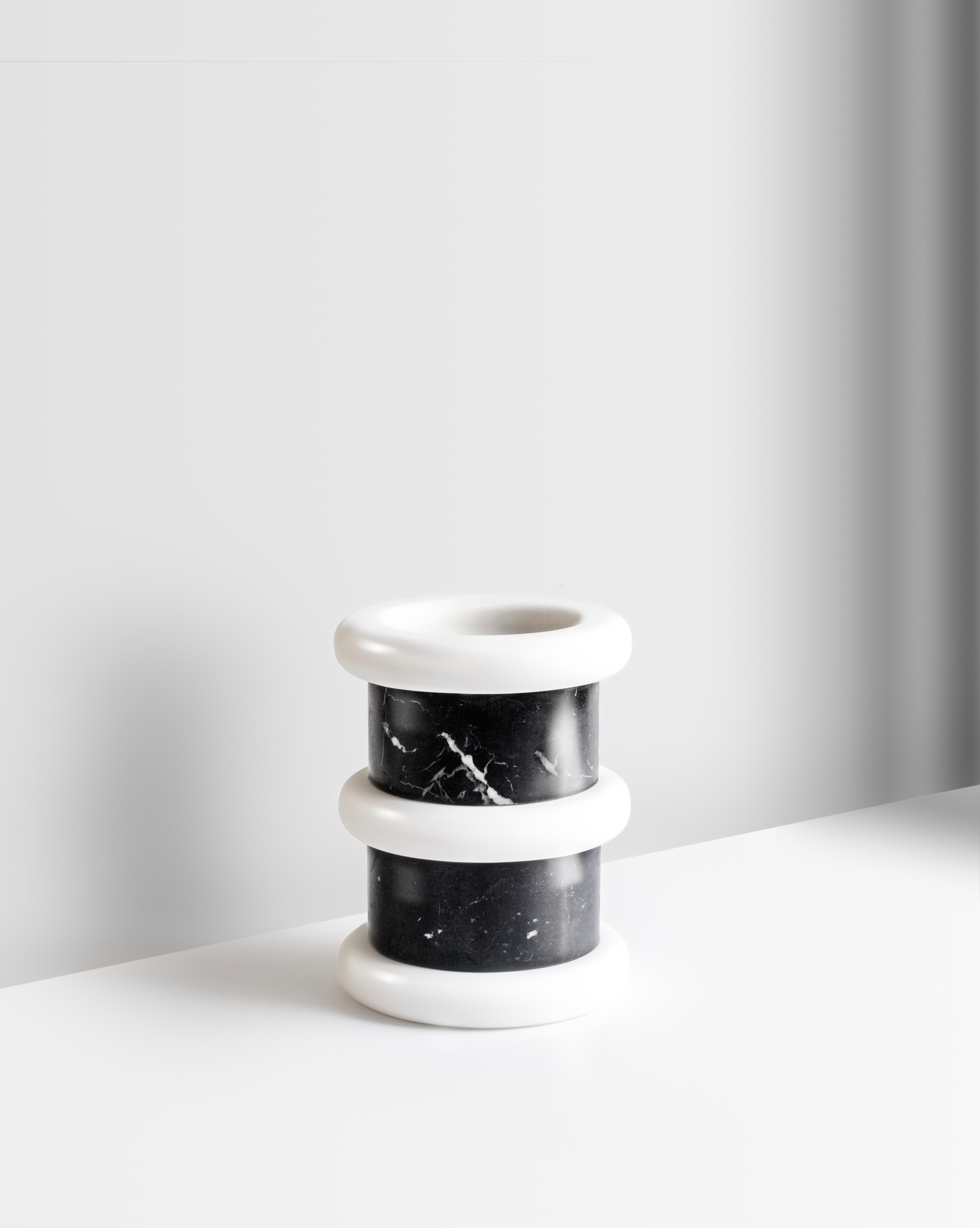 This handcrafted “Lumière” marble vase made in Tuscany, Italy, features an expressive silhouette with charming rounded volumes and pleasant proportions. Made from the elegant Spanish “nero marquiña” black marble with white rings made from the pure
