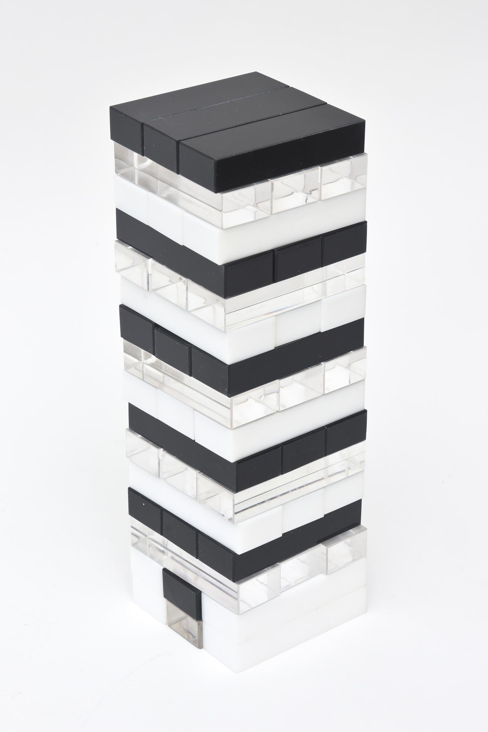 This vintage 1970s black and white Lucite tower sculpture is interactive as one can build forms from the disks. You can place some on the inside and others on the outside as if you are making a statement. There is a clear transparent Lucite sleeve
