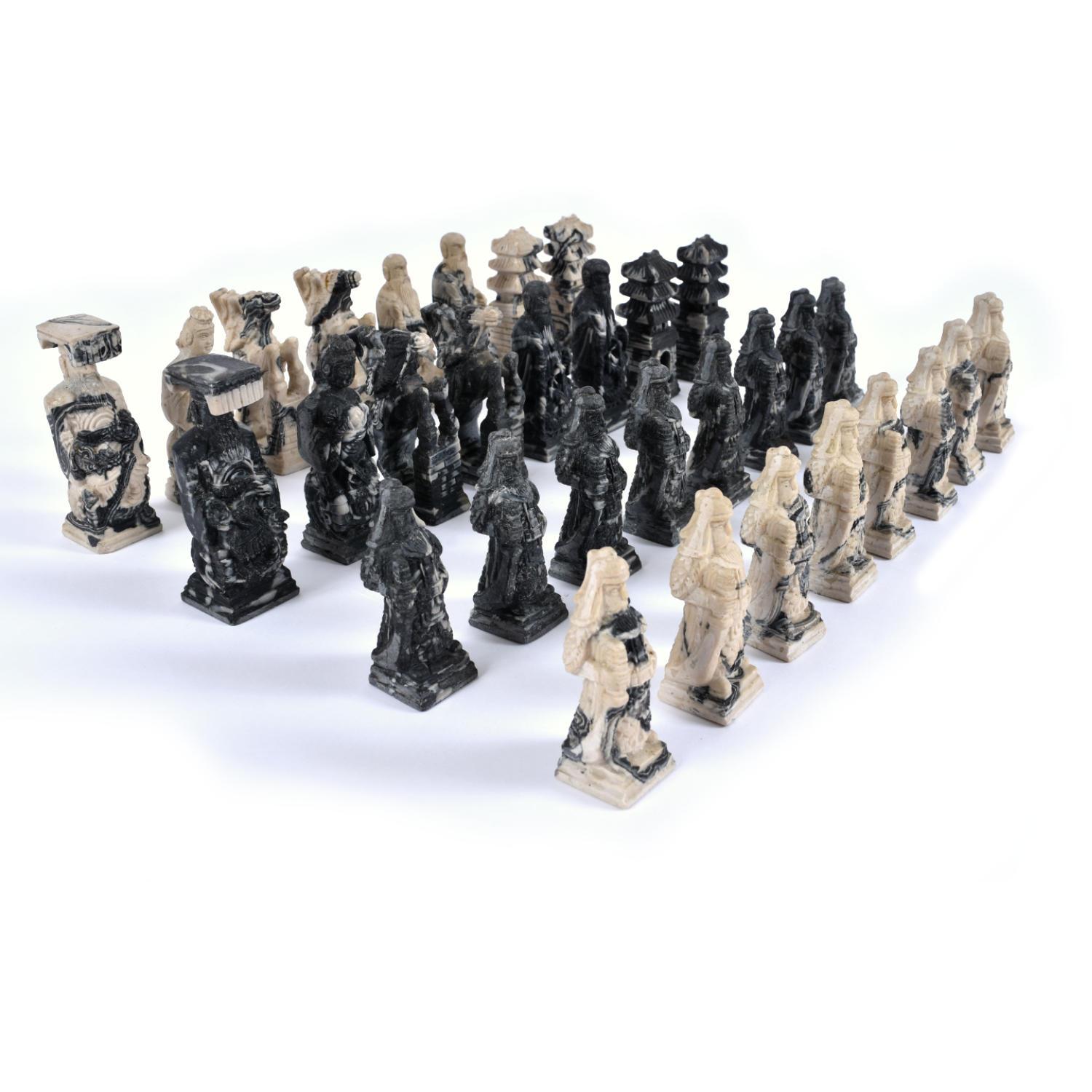 Exquisitely detailed set of vintage Chinese theme chess pieces carved in a stone-like resin. The standard 32-piece set features a group of black marbled and white marbled figures. The pieces are carved from a resin composite materials that looks and