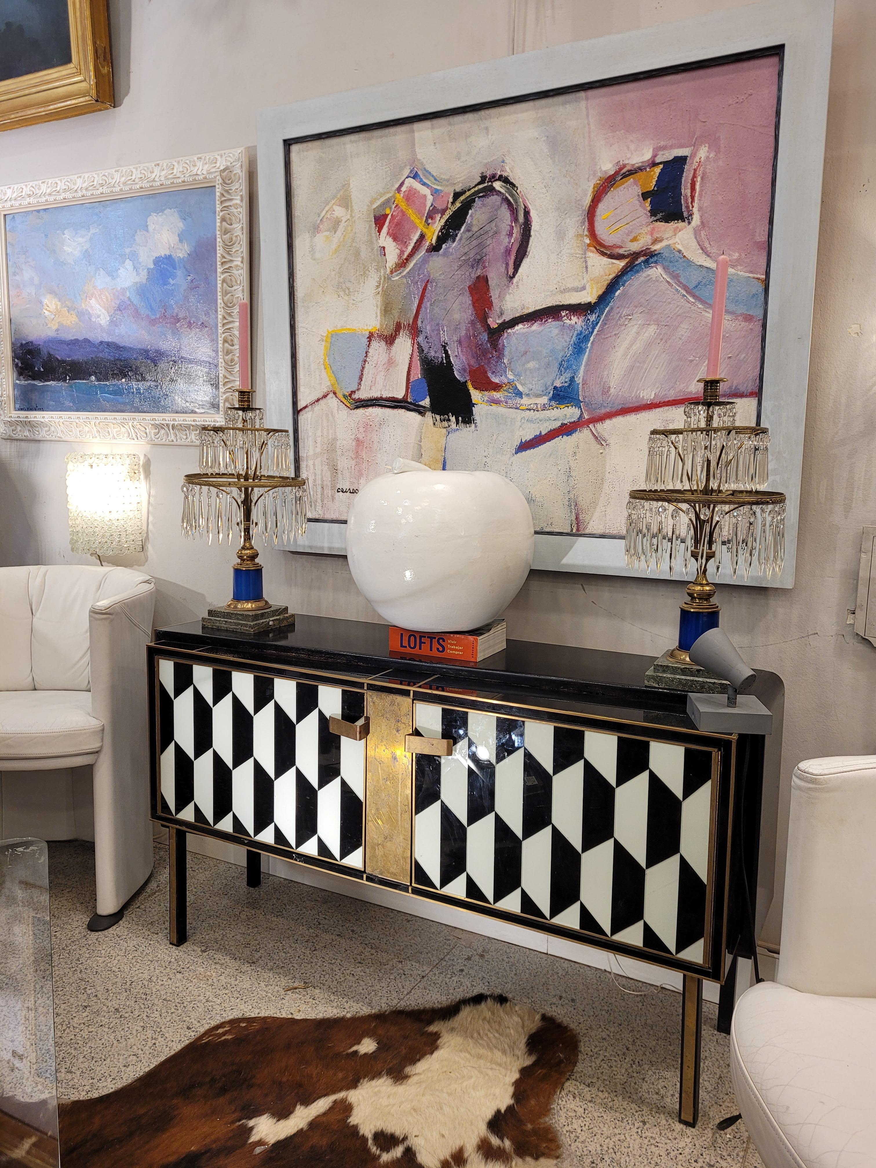 Gorgeous bar cabinet made of Murano glass and golden brass, original from the 1970s, midcentury style, Italy. With a rectangular profile, this small sideboard or cabinet powerfully draws attention thanks to the black and white geometric pattern of