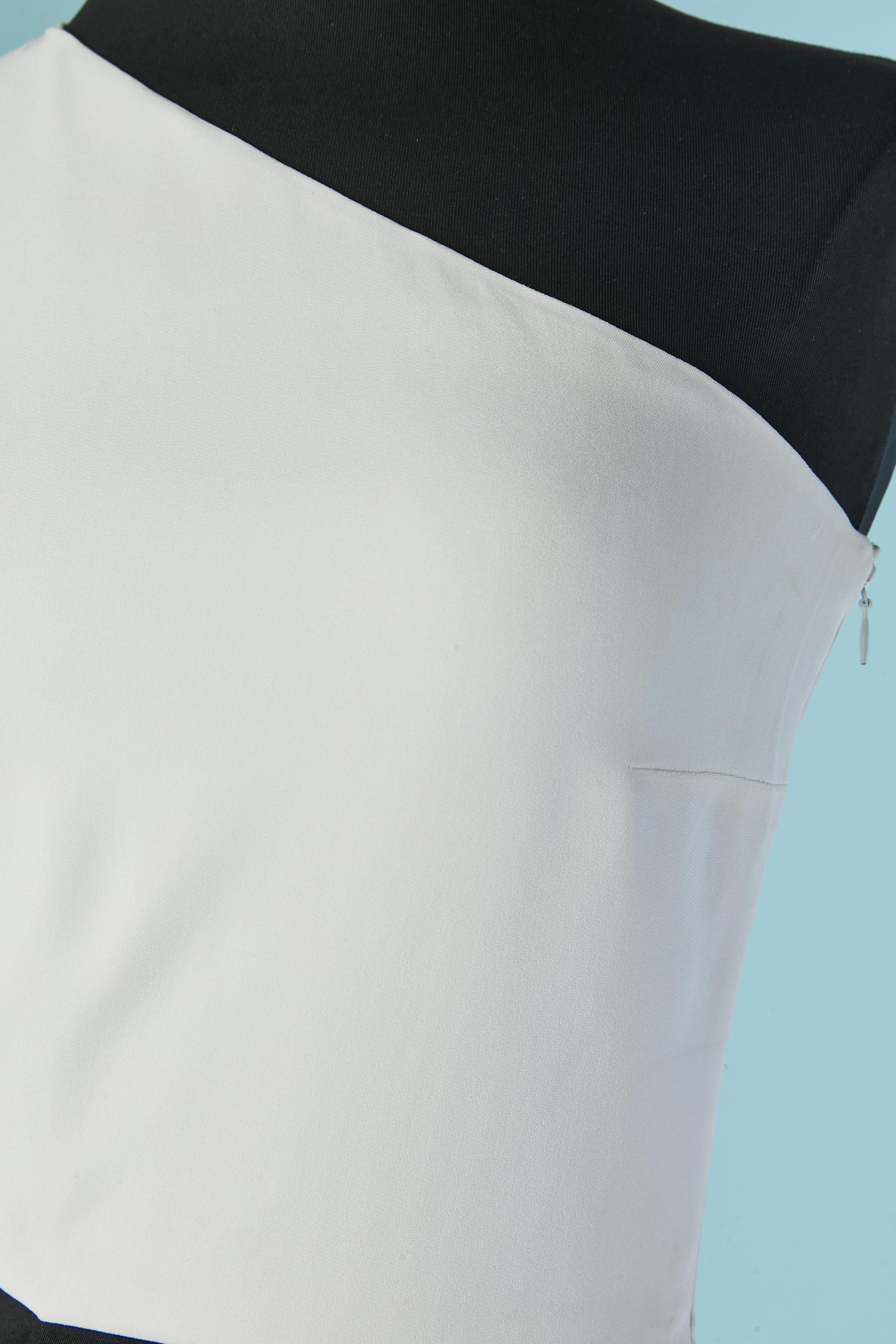 Robe de soirée noire et blanche à une épaule avec traîne. Composition du tissu extérieur : 64% rayonne, 32% acétate 4% élasthanne. Doublure en soie. Ouvert sur le côté droit de la taille. 
Fermeture à glissière invisible sur le côté gauche + crochet