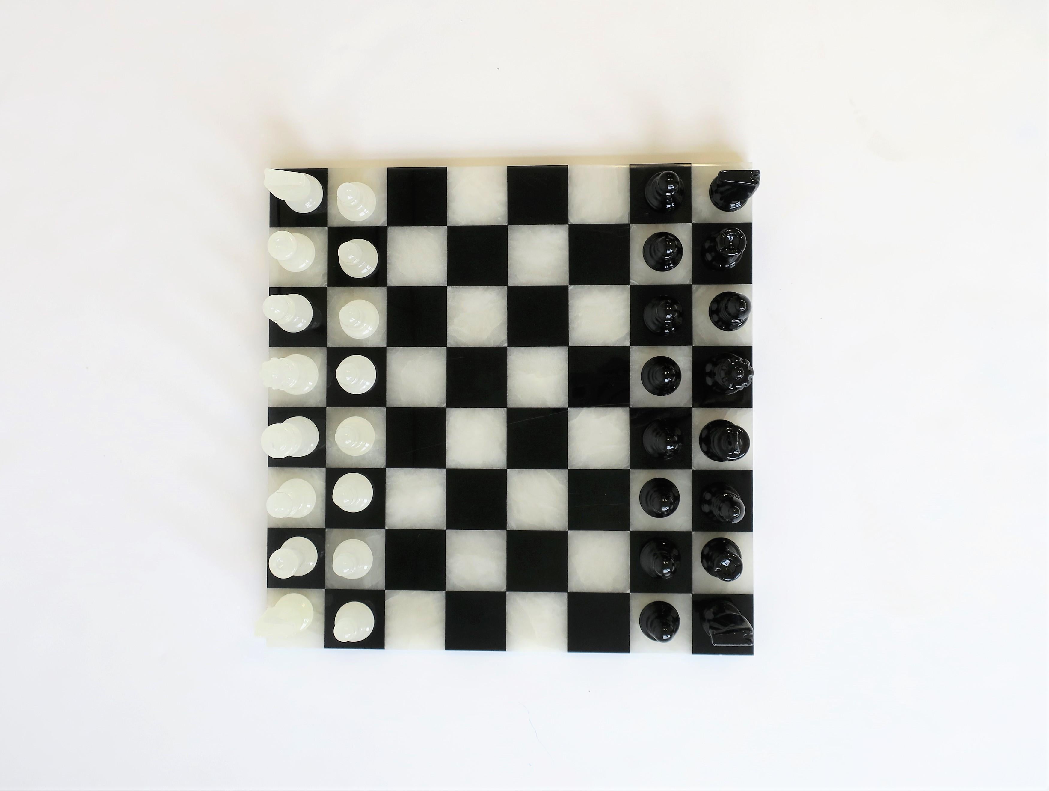 A chic black and white chess and tic-tac-toe game set, with onyx and acrylic pieces, circa late 20th century. Game includes 'rules' for chess as show in images. Complete set includes black wood game box, onyx and acrylic board, and all pieces (onyx
