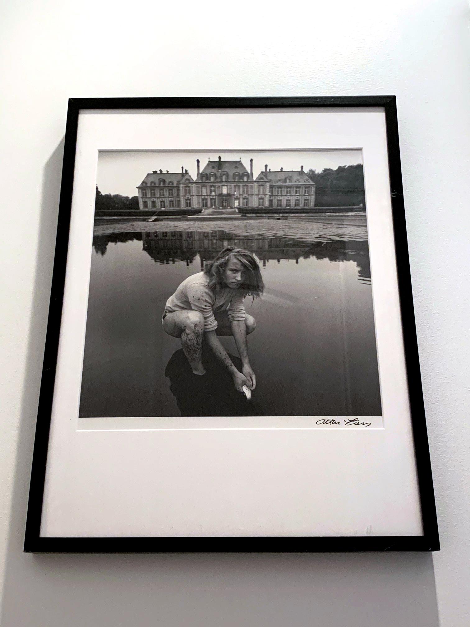 A large black and white photograph by American surrealist photographer Arthur Tress (born 1940-). The photo was entitled: Girl Collecting Goldfish, Chateau Breteuil, France. It was created in 1974 and it is not known when the photo on offer was