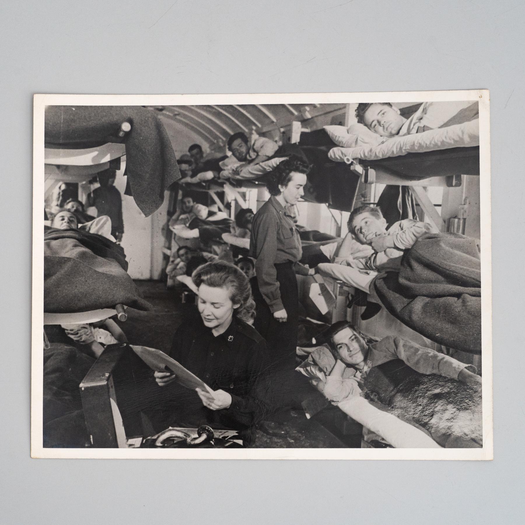Photographie en noir et blanc de Madeleine Carroll 

Madeleine Carroll joue de la musique pour les soldats américains dans un train médical de l'armée américaine pendant la Seconde Guerre mondiale, 1944.

En état d'origine avec une usure mineure
