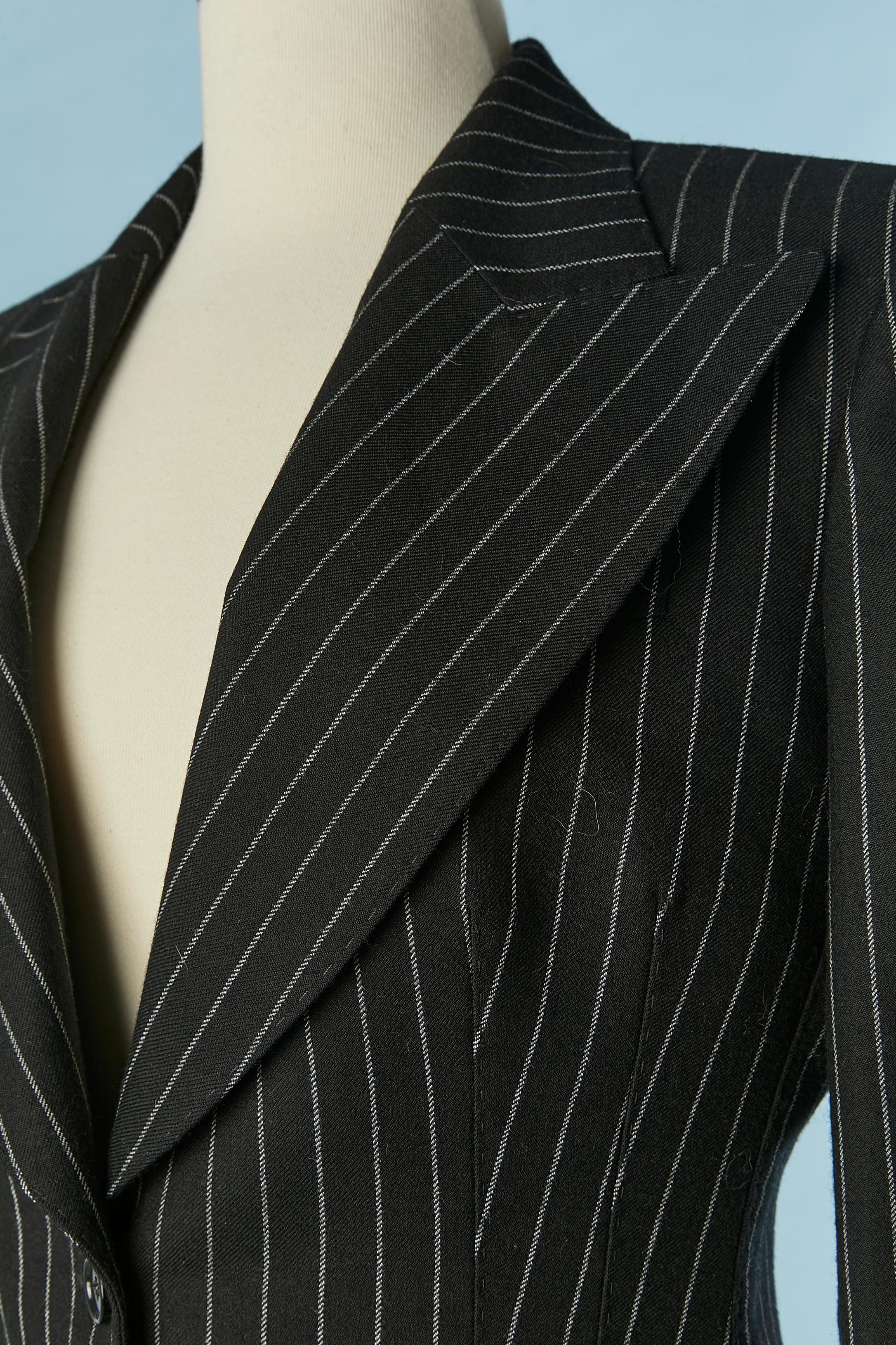 Black and white pin-striped trousers-suit. 
Main fabric composition: 96% wool, 4% polyester. Lining: 92% silk, 8% elasthane. 
Pocket on both side, shoulder-pad. 
SIZE 40 (It) M 
