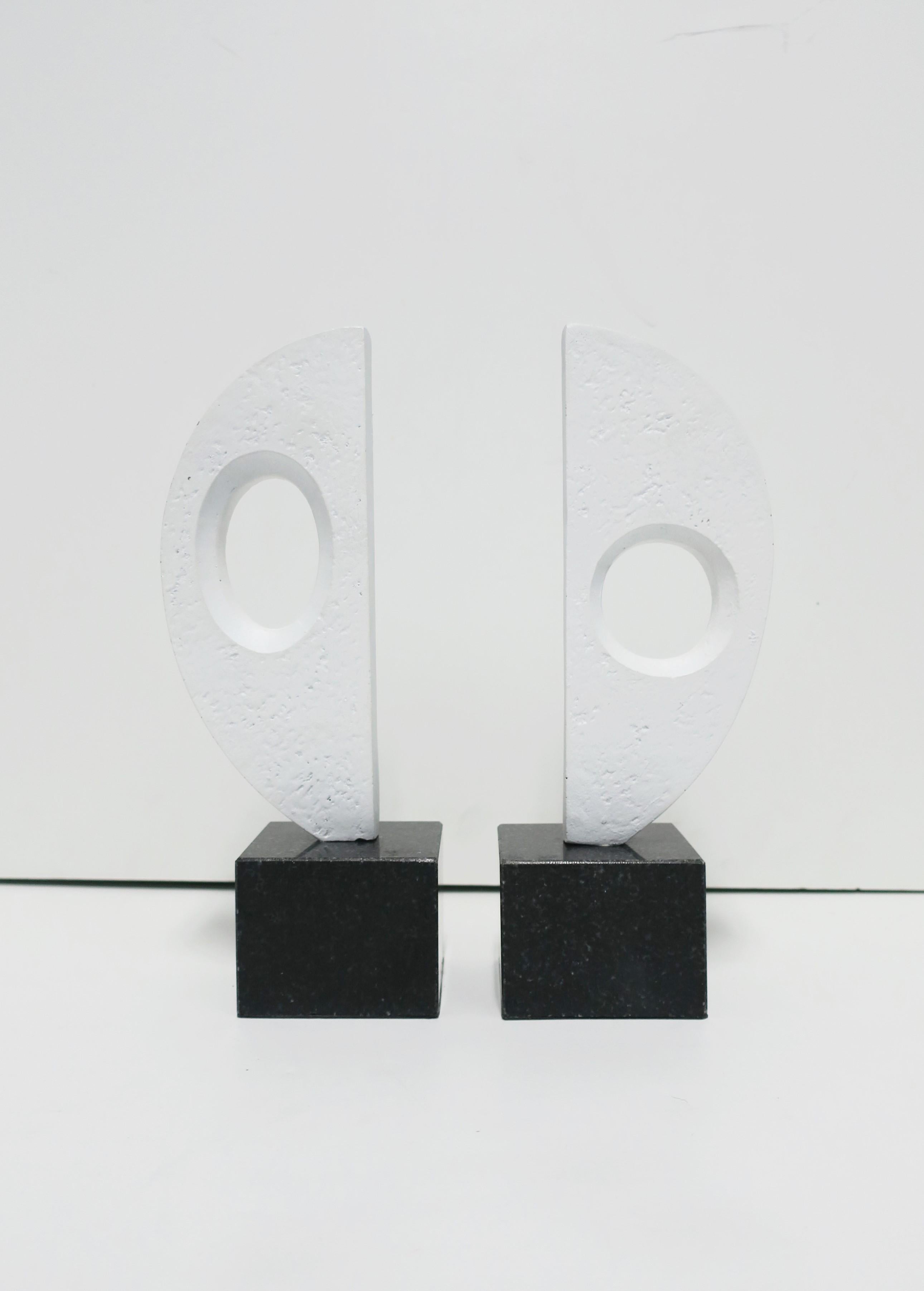 A substantial and relatively tall pair of black and white abstract sculptures decorative objects or bookends; pair are white plaster on black marble or granite bases. Demonstrated as bookends in image #6. Pair in images #3, 4 and 5 as decorative