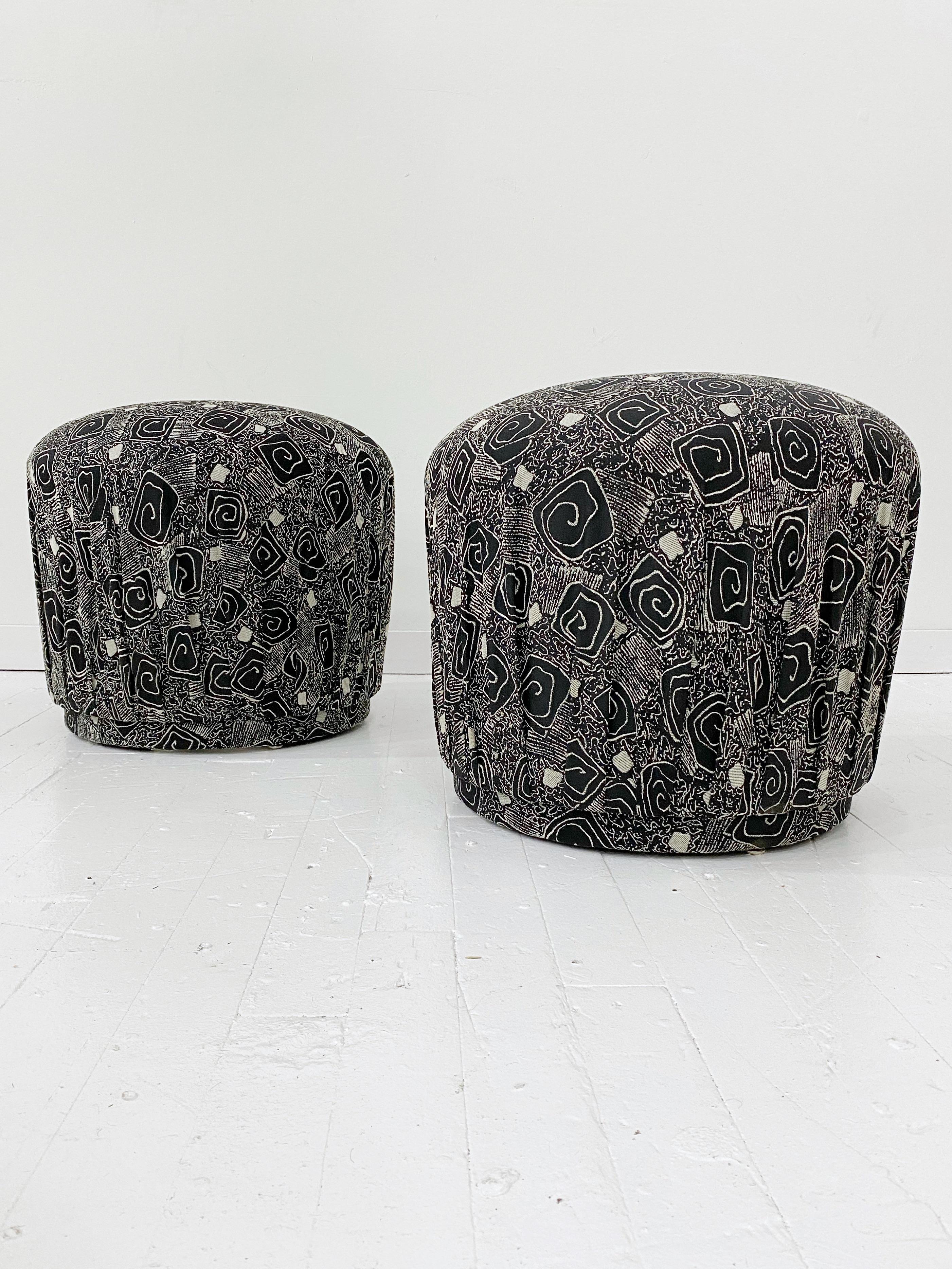 Black and white upholstered pouf ottoman. Abstract spiral jacquard fabric pleated at plinth base. Pair available.
