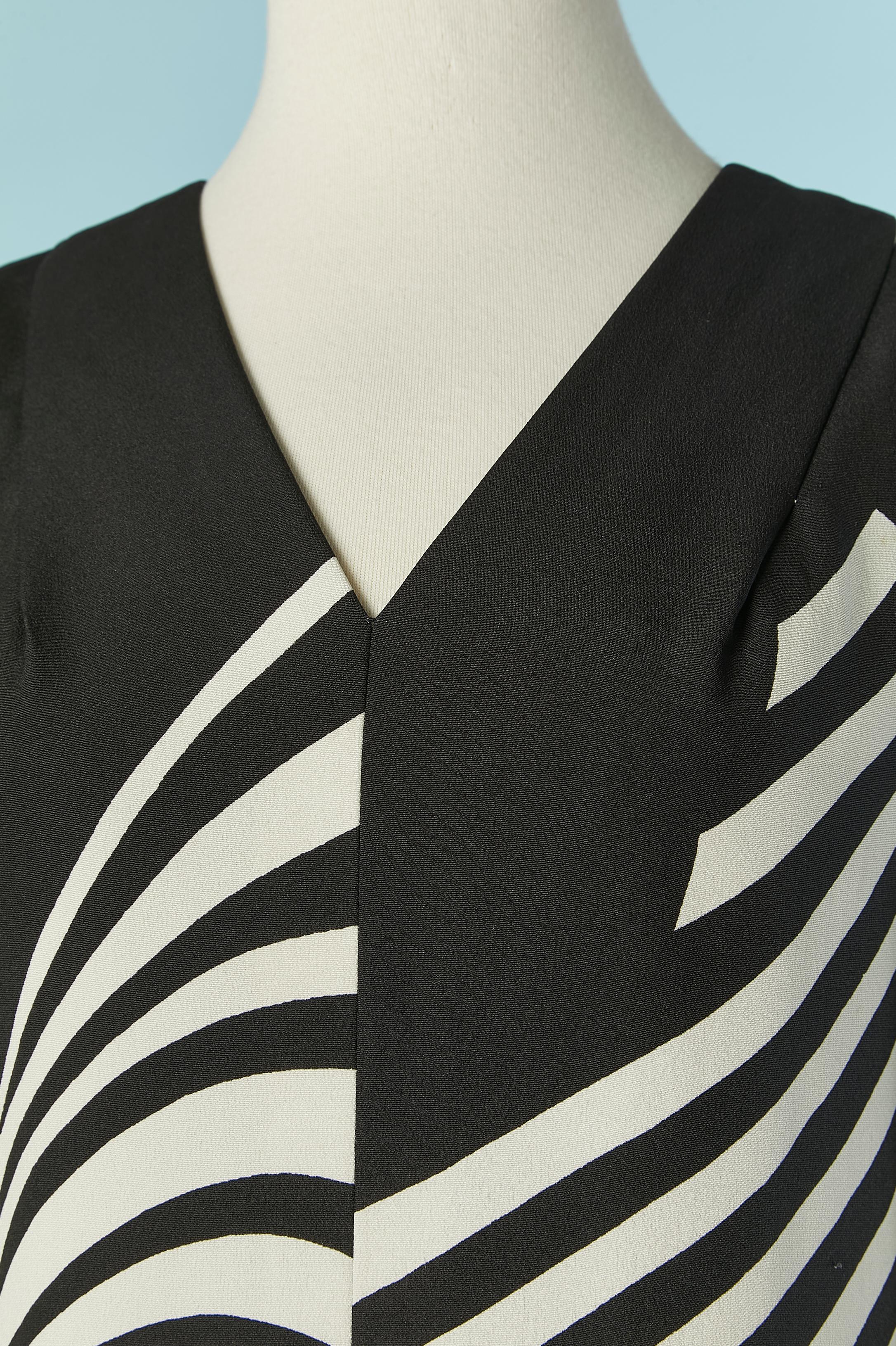 Black and white printed jumpsuit . No fabric tag composition but the shell is probably rayon and the lining is definetly in silk. Decorative Buttons with black beads on the sleeve and one on the top middle back. Split on the bottom edge of the