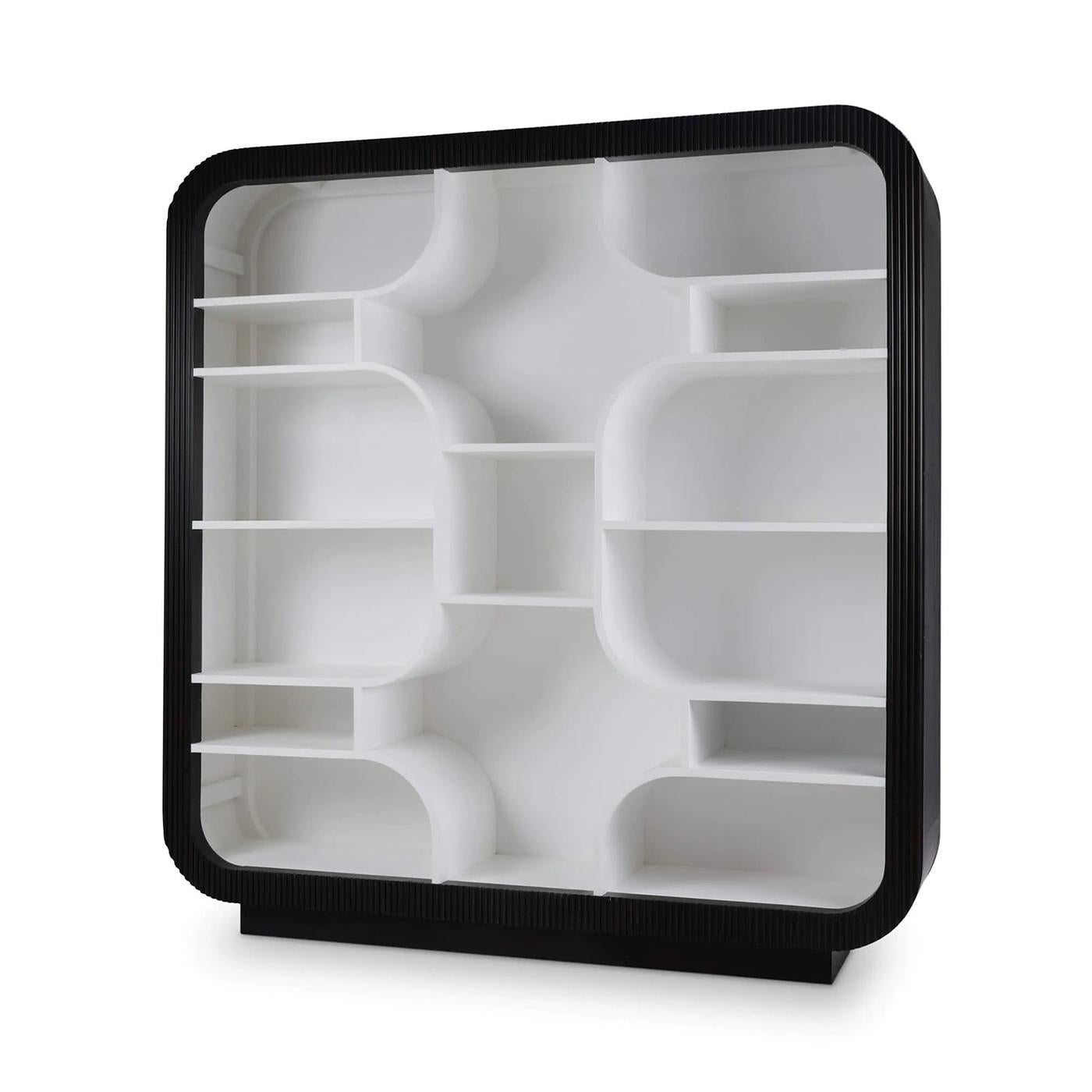 With a modular grid of softly curved cubbies, it offers a visually striking backdrop for books, ceramics, or collected objects. The fluted frame is finished in a black, while the interior is painted in a bright True White for brilliant contrast and