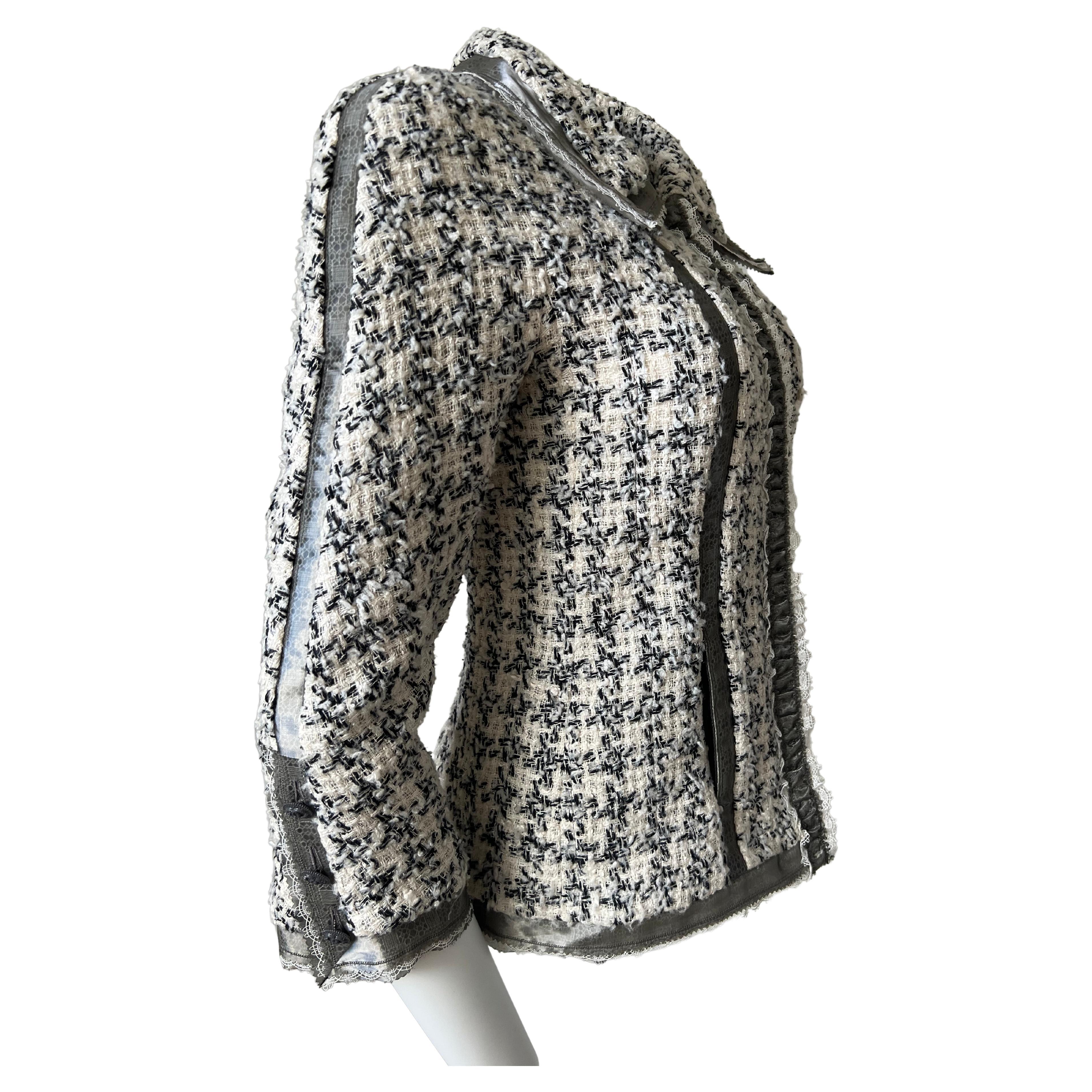 Superb black and white silk tweed jacket. Strips of gallon of white Pasementerie stitched by a strip of black silk. Zip closure marked Chanel, three buttons on the ends of each sleeve. A delicat and luxurious work make this Chanel Jacket a piece of
