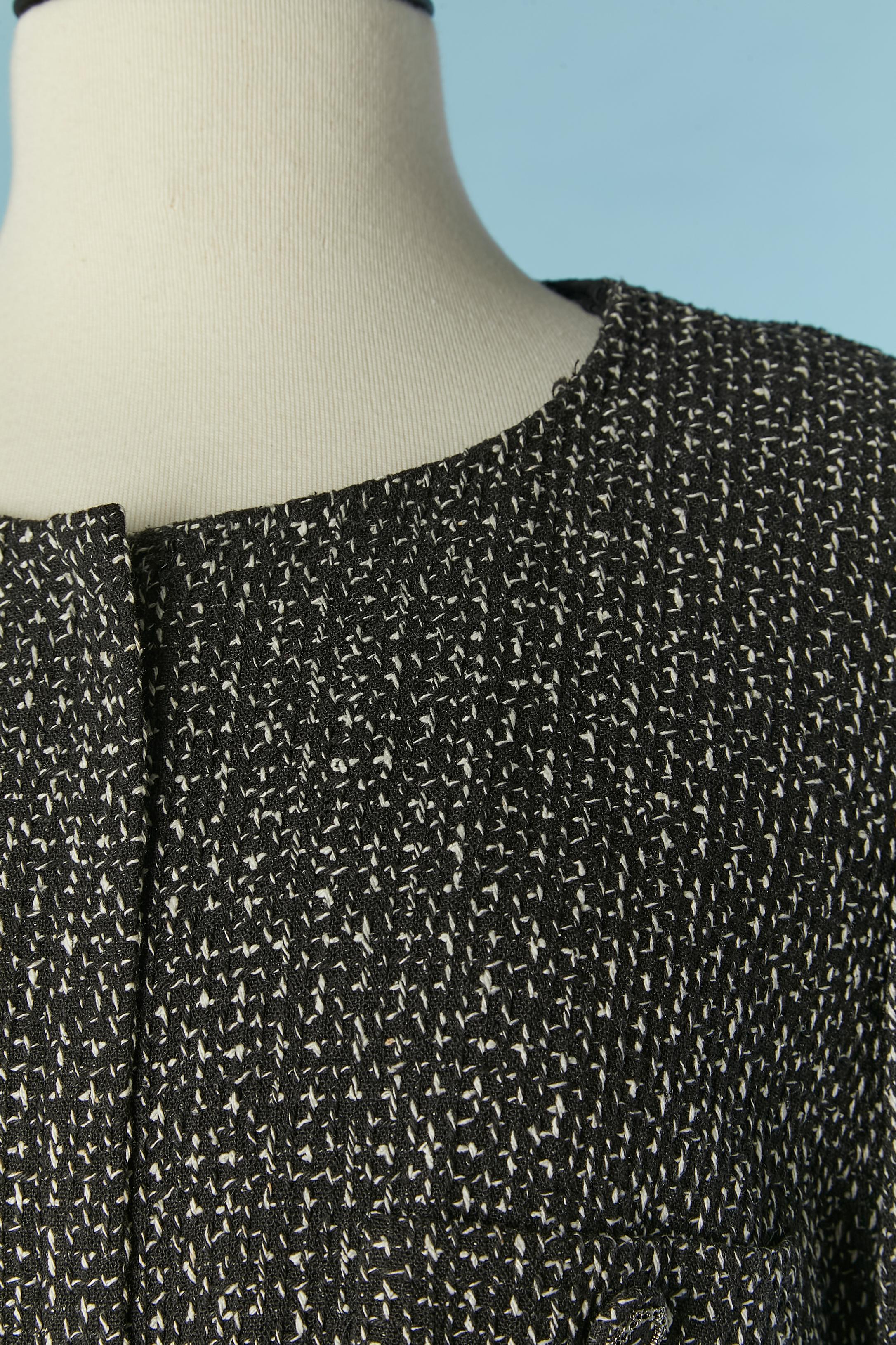 Black and white silk tweed jacket with hidden zip closure on the middle front. Lining composition: 86% silk, 14% elastane. 
Shoulder-pad. Tweed and chain button on the pocket and cuffs. Pocket on the bust. Chain inside on the bottom edge.
SIZE 42