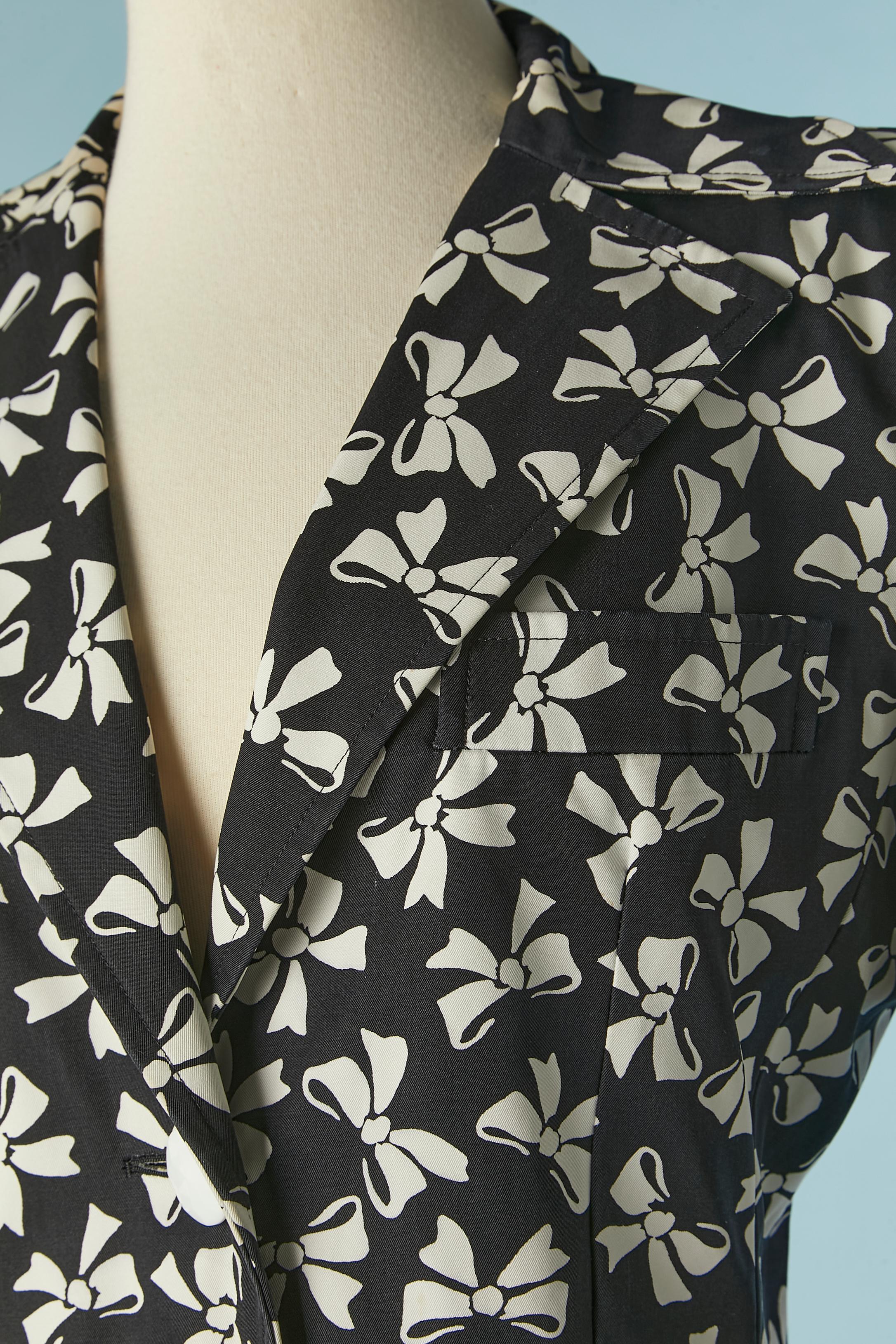Black and white skirt-suit with bow print. Main fabric: 100% cotton, lining: 55% acetate, 45% rayon. 
Shoulder-pad. Pocket on both side and one pocket on the top side on the bust. 
SIZE 38 (Fr) L for the jacket
SIZE 40 (Fr) M for the skirt 