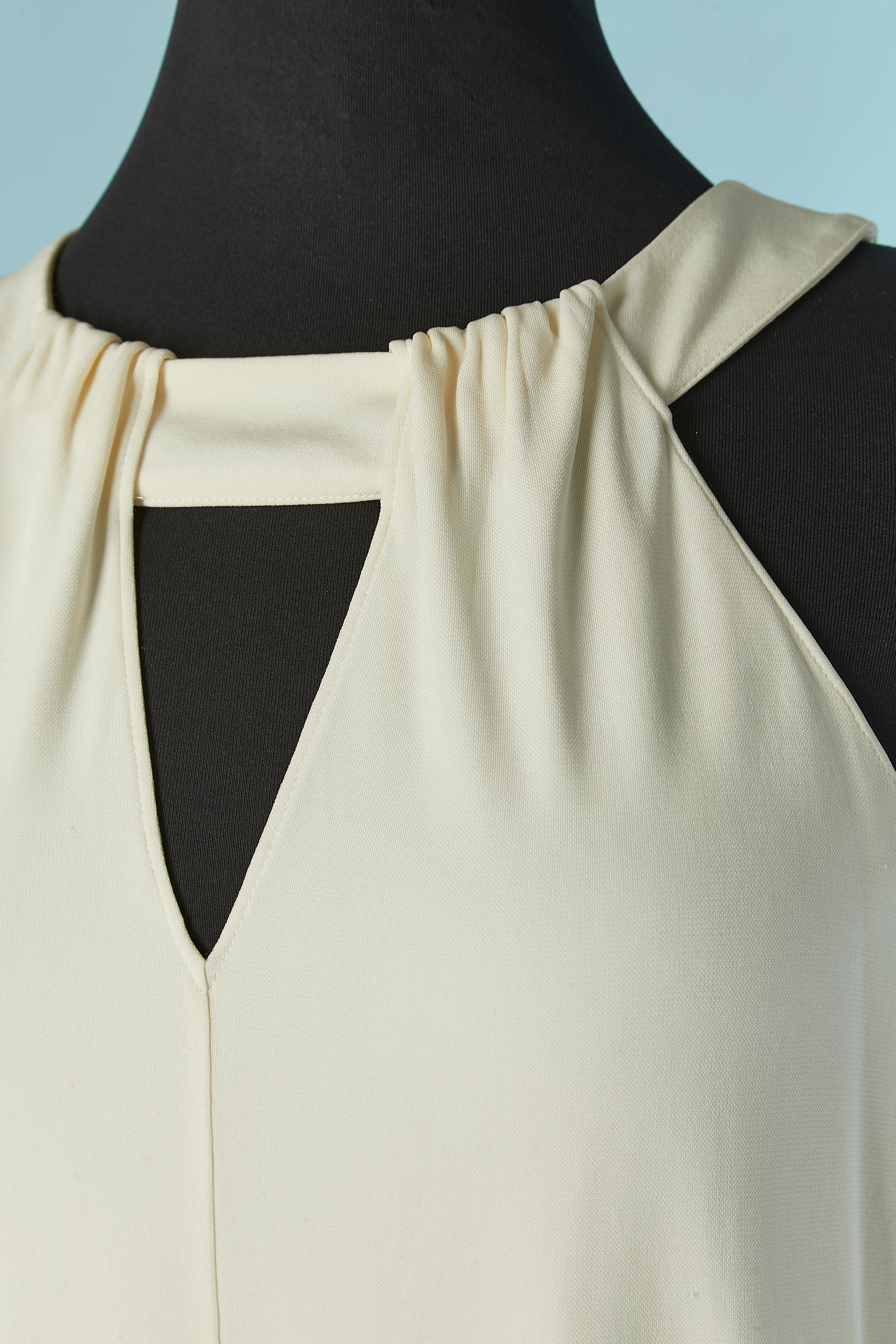 Tuta senza maniche in bianco e nero. Non c'è l'etichetta della composizione del tessuto, ma probabilmente si tratta di rayon e la fodera di poliestere. 
Chiusura con zip invisibile al centro della schiena + gancio e occhiello + bottone e asola.