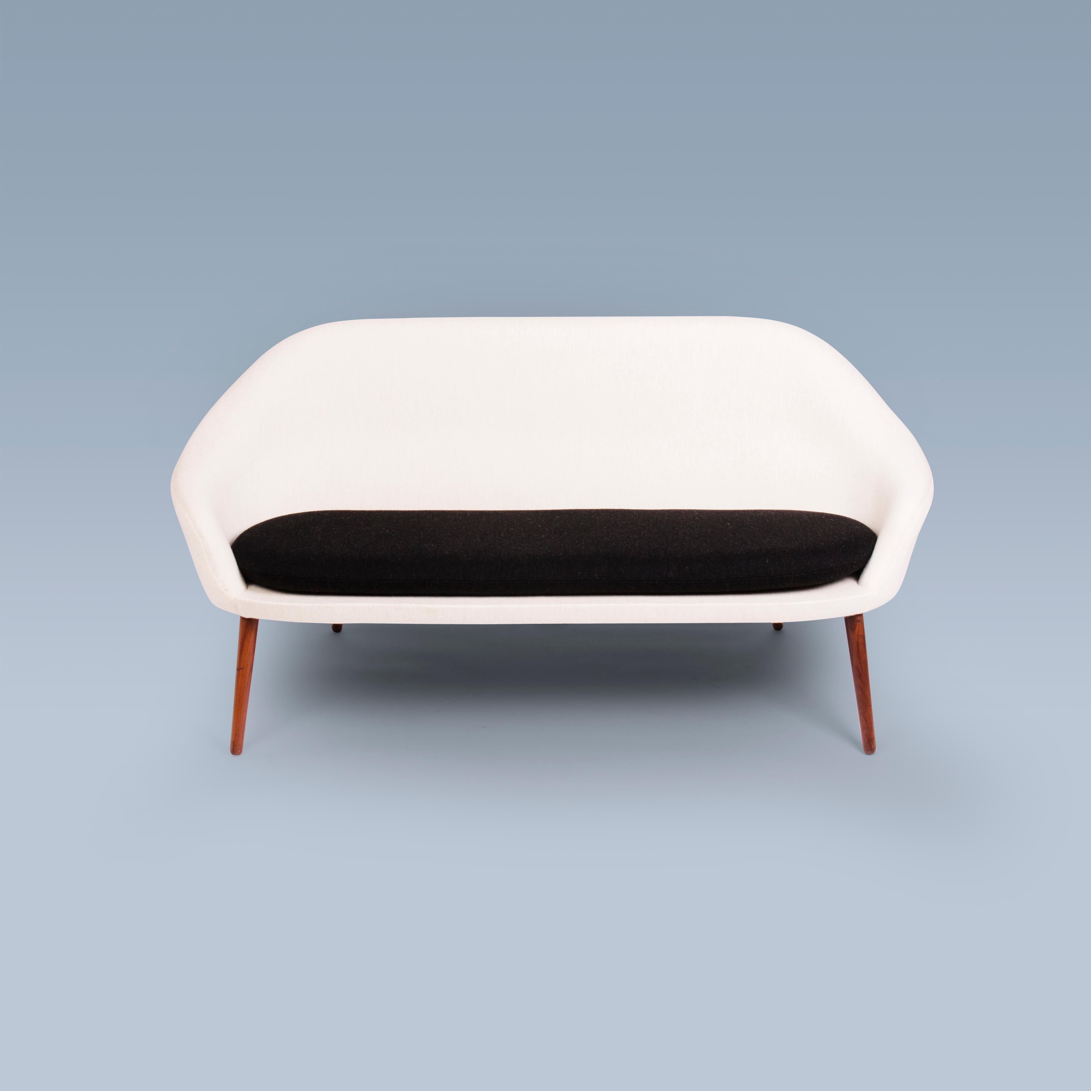 This sofa with a large seat cushion was designed in 1956 by Hans Olsen (1919-1992). The sofa is model number 187. It is upholstered with white and black Savak wool by Gabriel. Its legs are of stained wood.
The sofa is executed and marked by Bramin