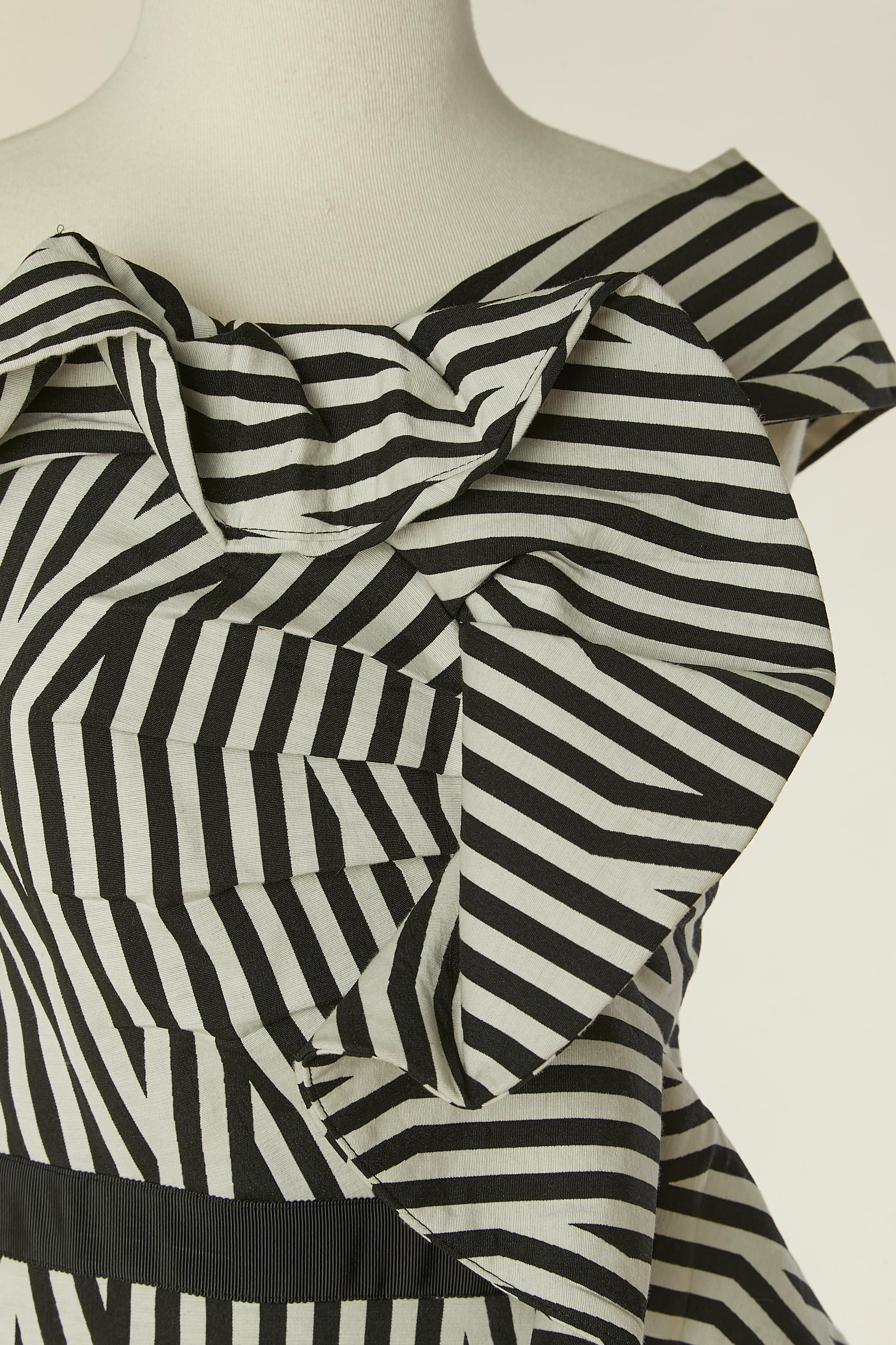 Schwarz-weiß gestreiftes Cocktailkleid. Zusammensetzung des Stoffes: 62% Polyester, 35% Baumwolle, 3% Elasthan. Futter: 100% Polyester
Reißverschluss in der hinteren Mitte. Gros-Korn-Taille . 
GRÖSSE M