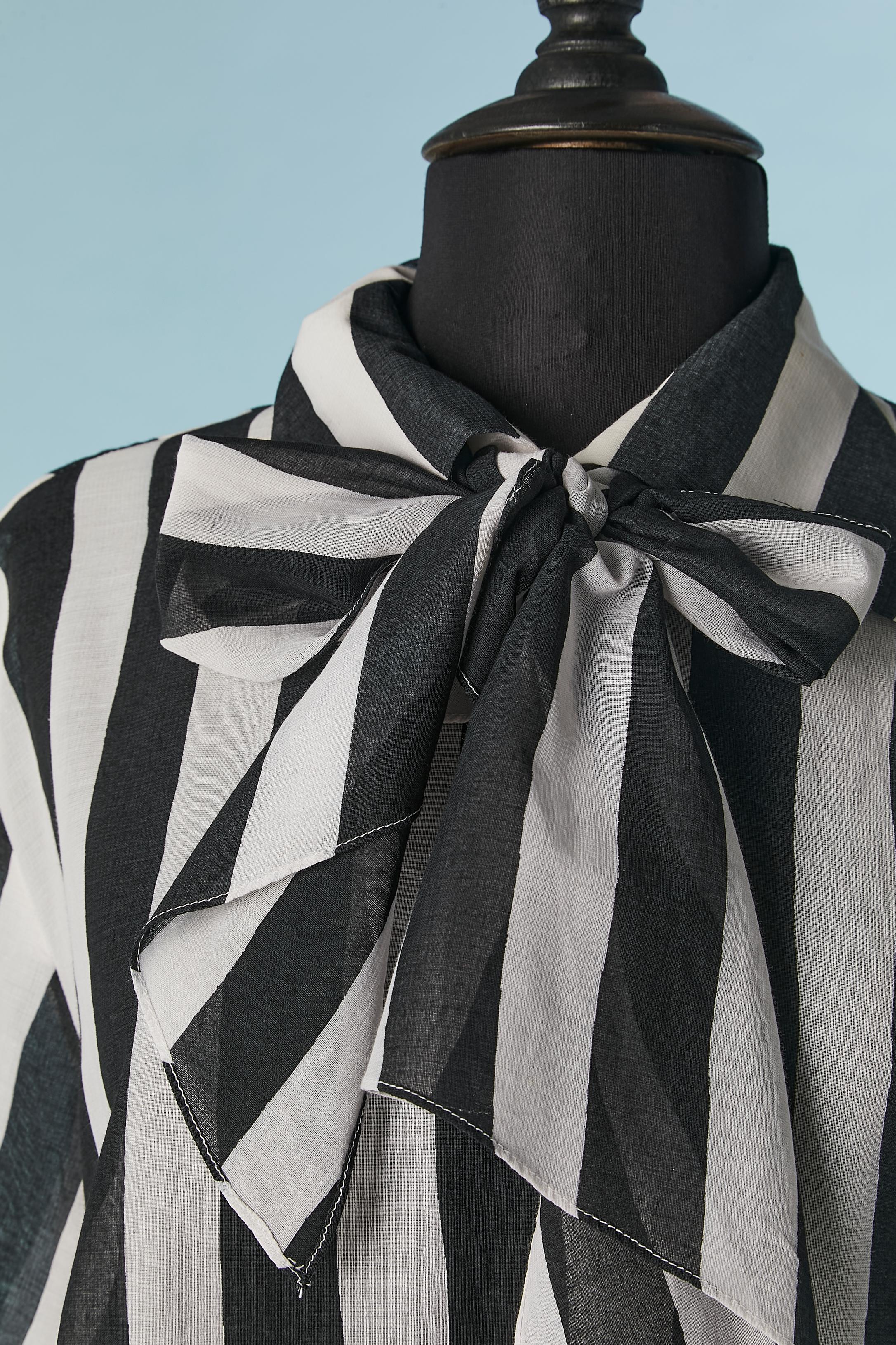 Black and white striped short sleeve blouse with bow. No fabric composition tag  but probably cotton and polyester. 
Button and buttonhole closure on the top middle back. 
SIZE 14 (US) L 