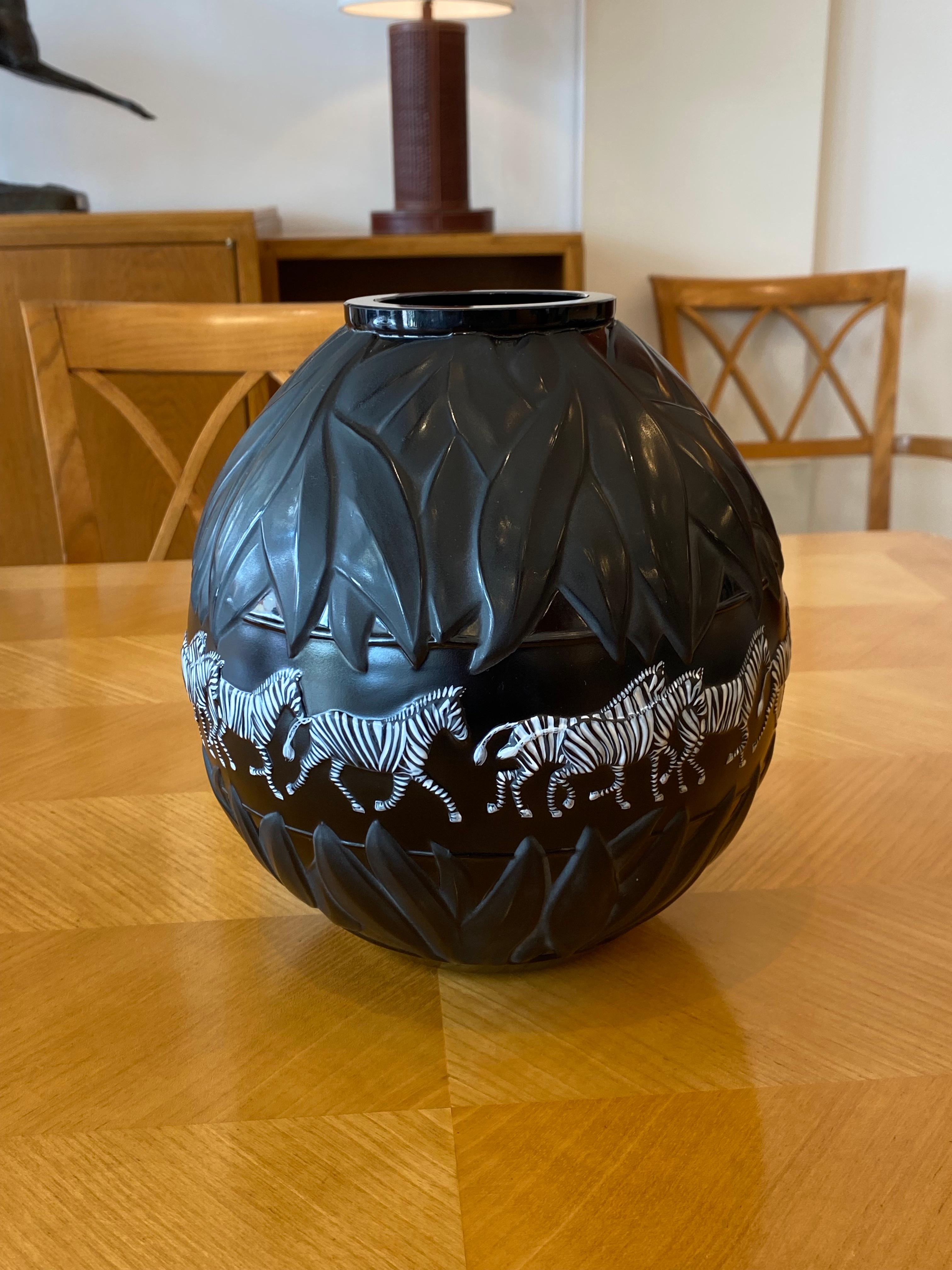 Lalique Tanzania black vase. Limited Edition. Signatured: France & Numbered 544 etched on base. Mouth blown molded black glass decorated in relief with hand painted center frieze of enameled black & white zebras. 
Made in France
Circa: