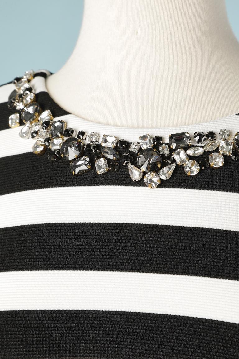 Black and white top with stripes and rhinestone neckless. Small opening in the middle back with pearls to close it. 
SIZE M 