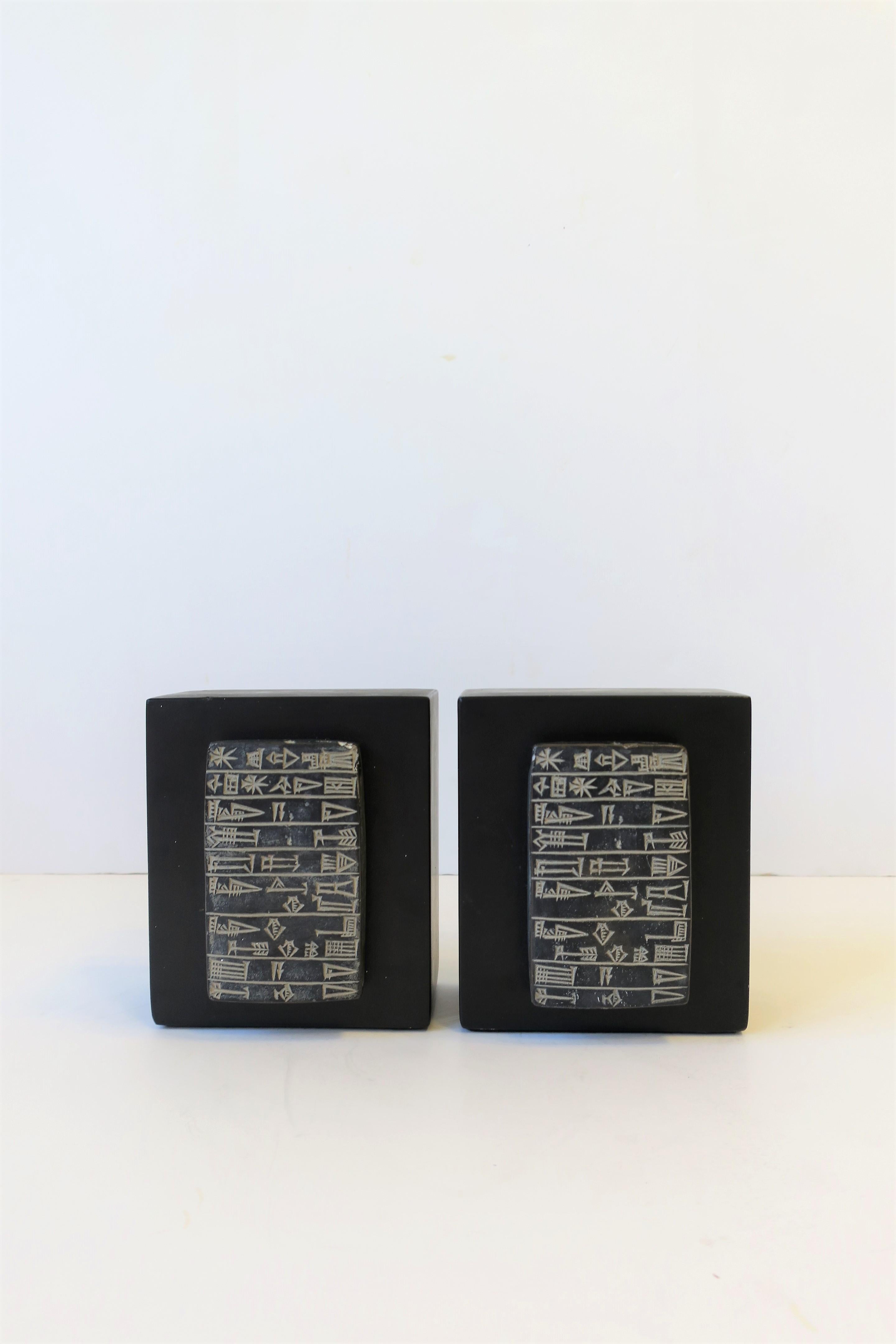 A pair of black and white plaster bookends with ancient tribal design, circa late-20th century. Each measure: 4.75