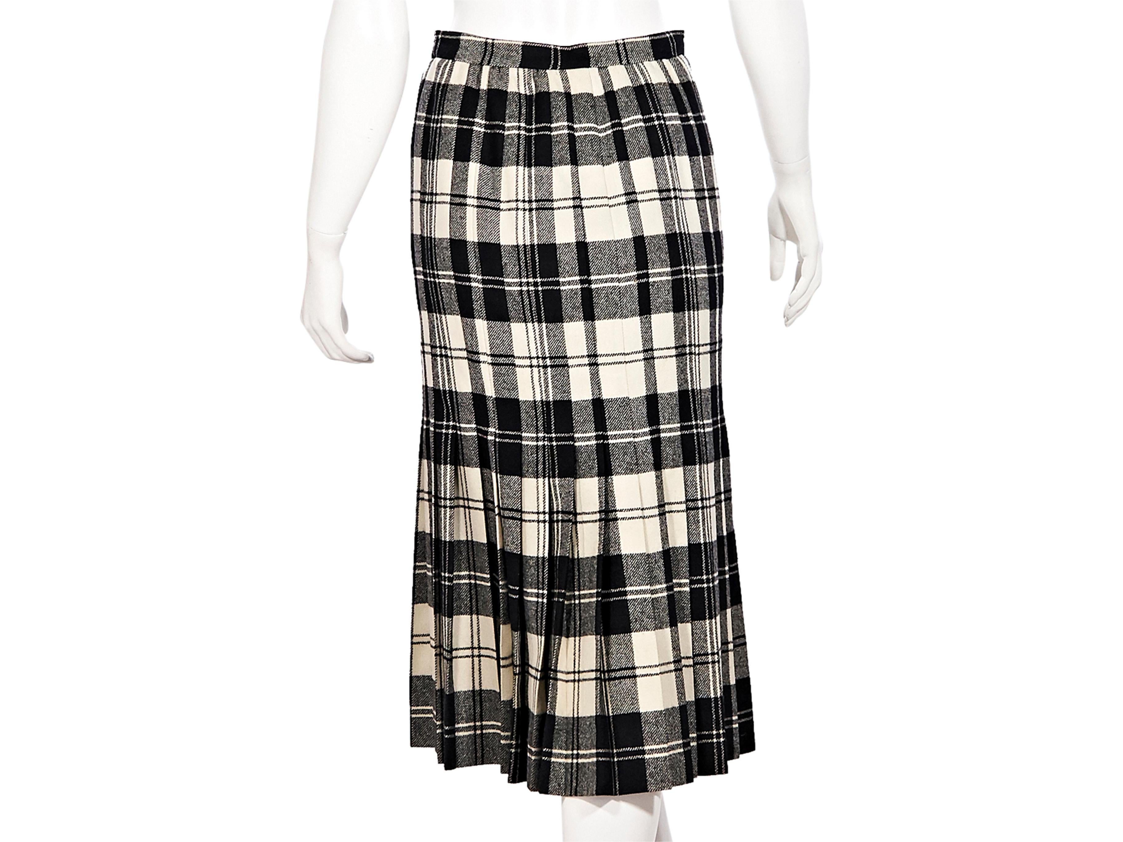 Product details:  Black and white plaid pleated mini skirt by Valentino. Button closures at front. High-waist. Midi-length. Style yours with a black silk blouse. 24