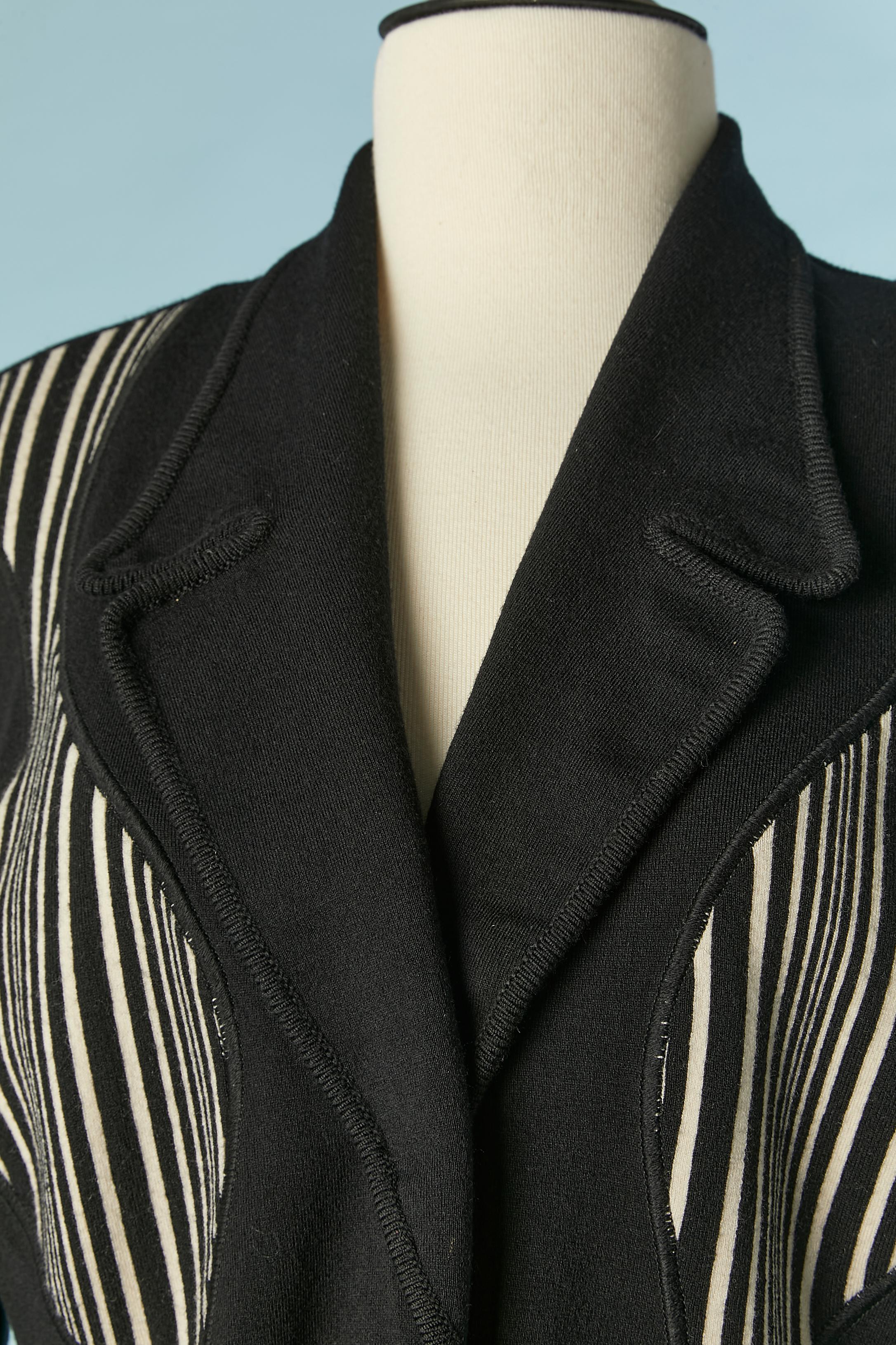 Veste en jersey de laine noir et blanc à simple boutonnage avec fermeture à bouton-pression. 
Découpage. Poches sur les deux côtés. 
Composition du tissu : 85% laine, 10% polyamide, 5% élasthanne 
TAILLE M 