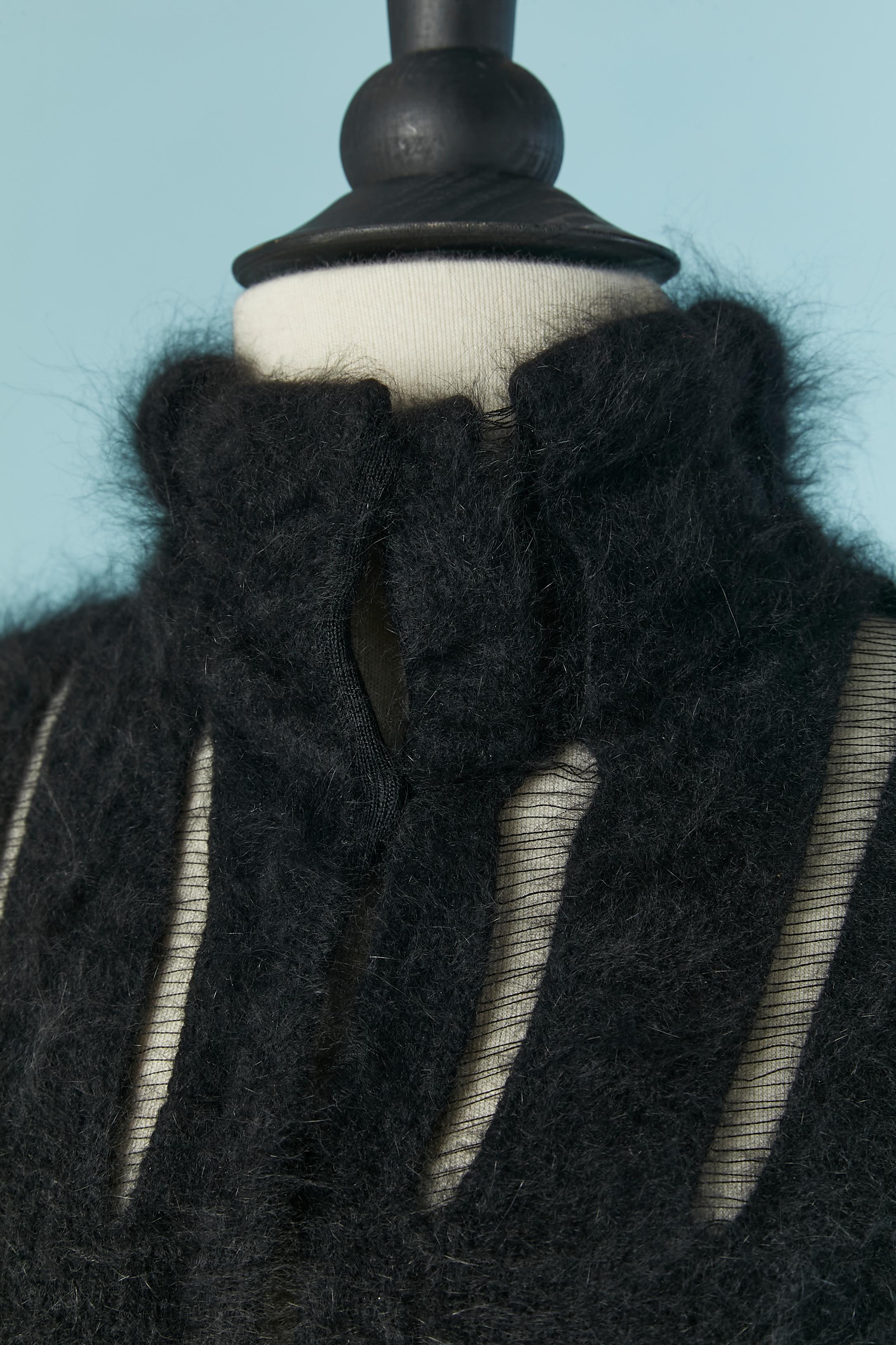 Black angora cardigan with see-through nylon lines. Fabric composition: 80% angora, 20% nylon. 
Button and buttonhole closure on the middle front. 
SIZE M on tag but fit more likely S 
