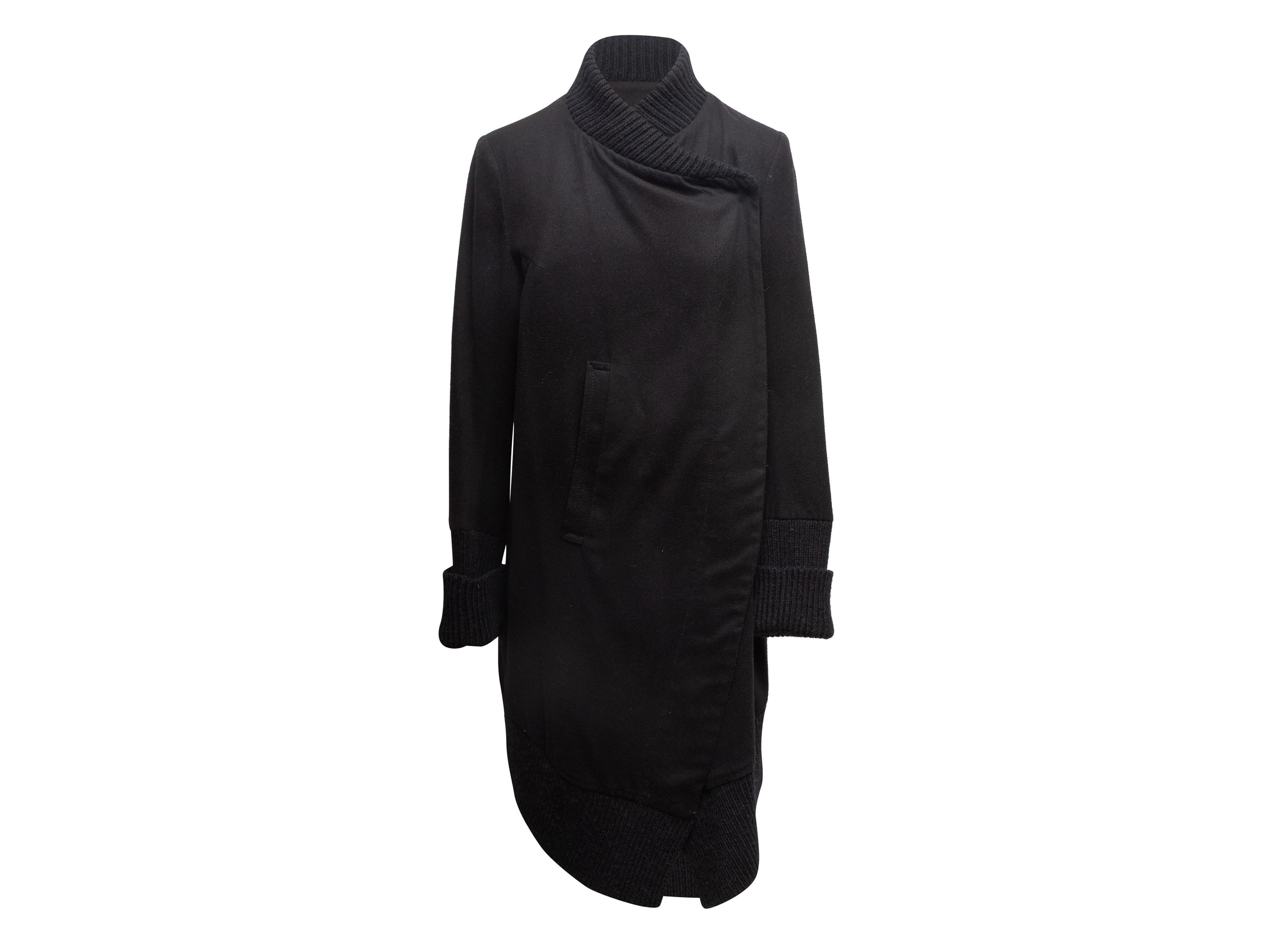 Cappotto lungo in maglia nera di Ann Demeulemeester. Scollo a V. Tasche posteriori. Chiusura frontale. Seno 34