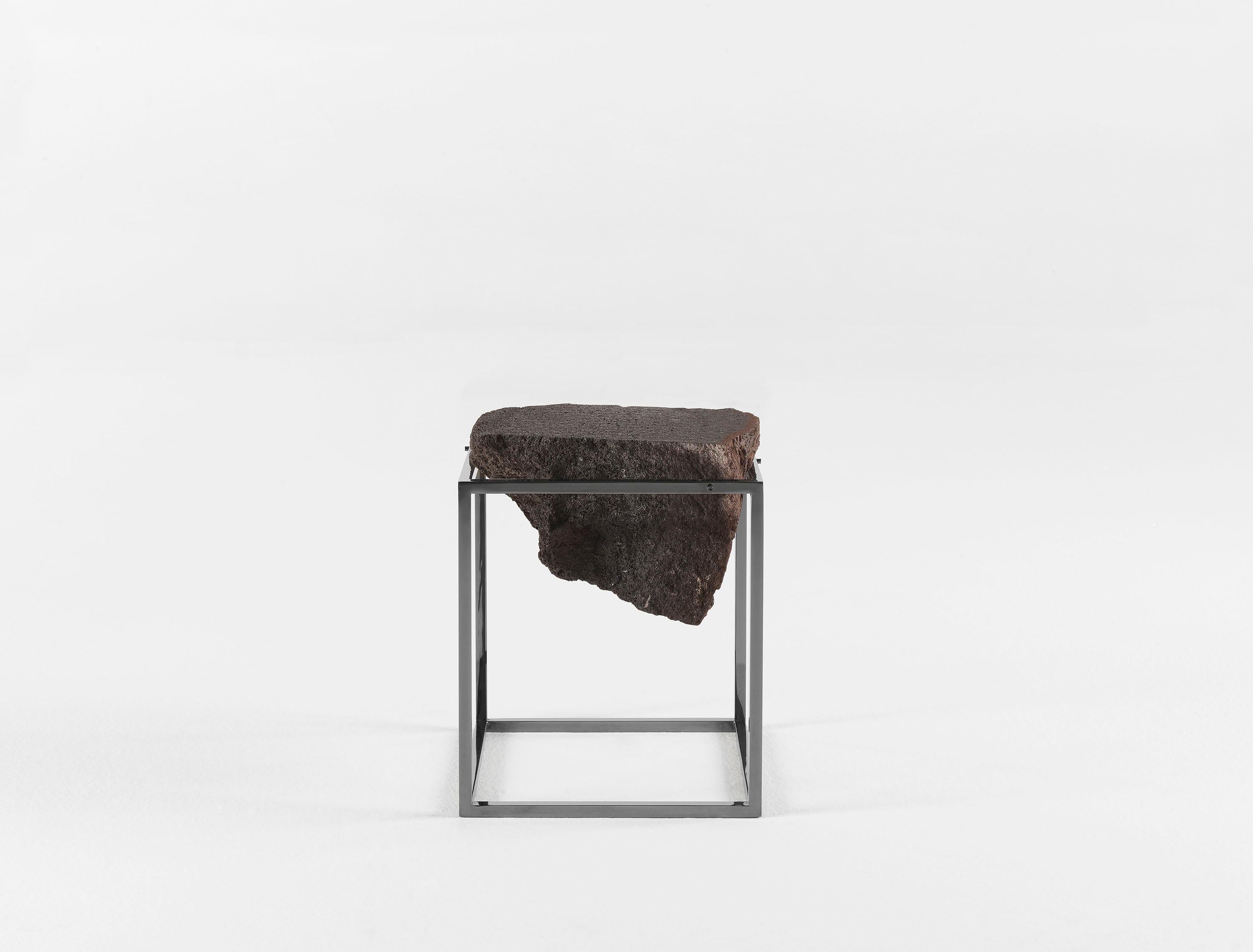 Black Antivol small side table by CTRLZAK
Materials: lava stone, metal structure in two finishes: polished black chrome and matte brass
Dimensions: 45 x 40 x 40 cm

A fragment of lava stone cut in half supported by a simple metal frame: nature