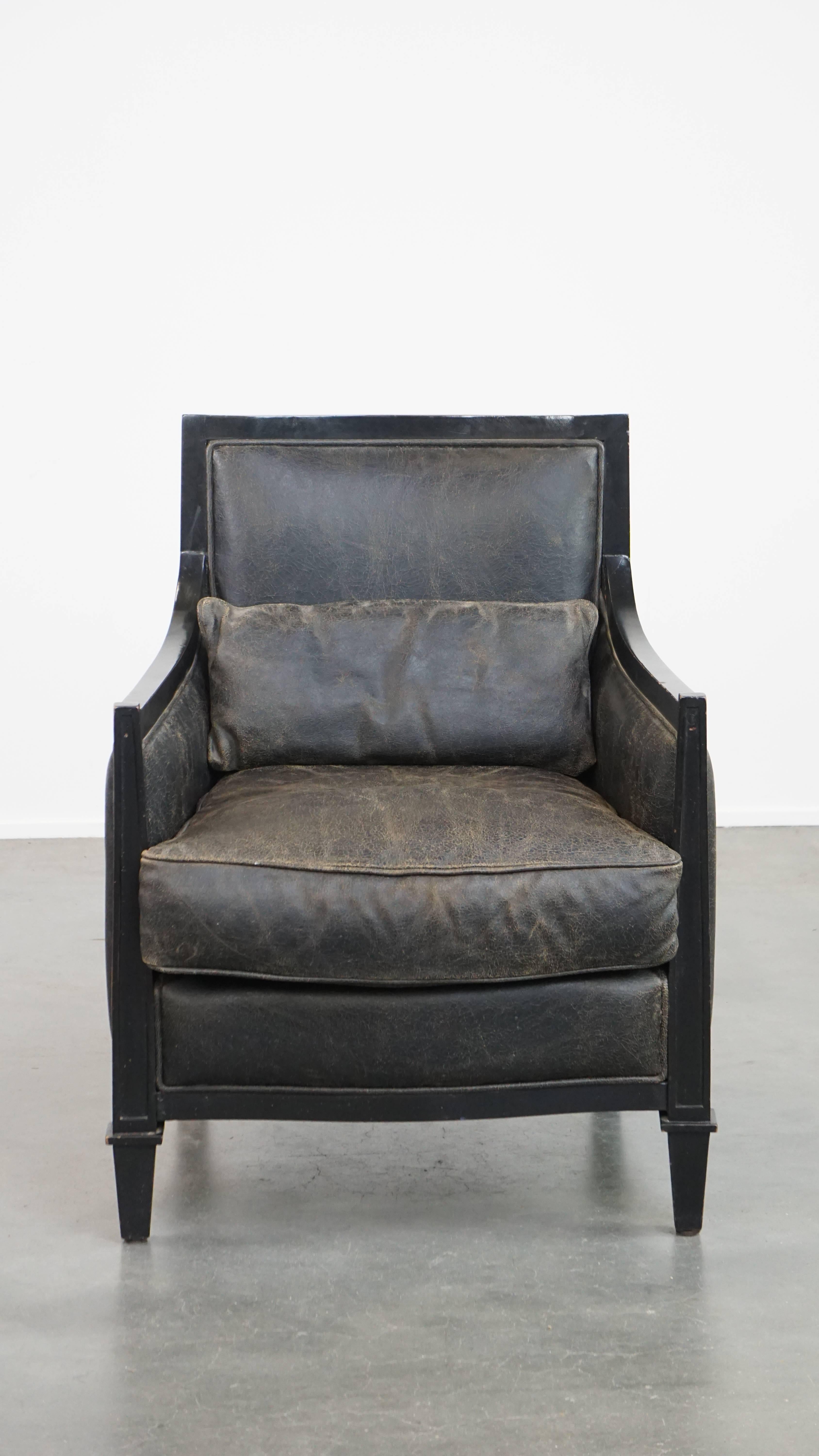 Packed with character, this unique cowhide leather armchair also exudes the timeless luxury and charm of Art Deco design. Its deep black color, combination with wood and sleek finish enhance this character. This armchair comes with a separate seat