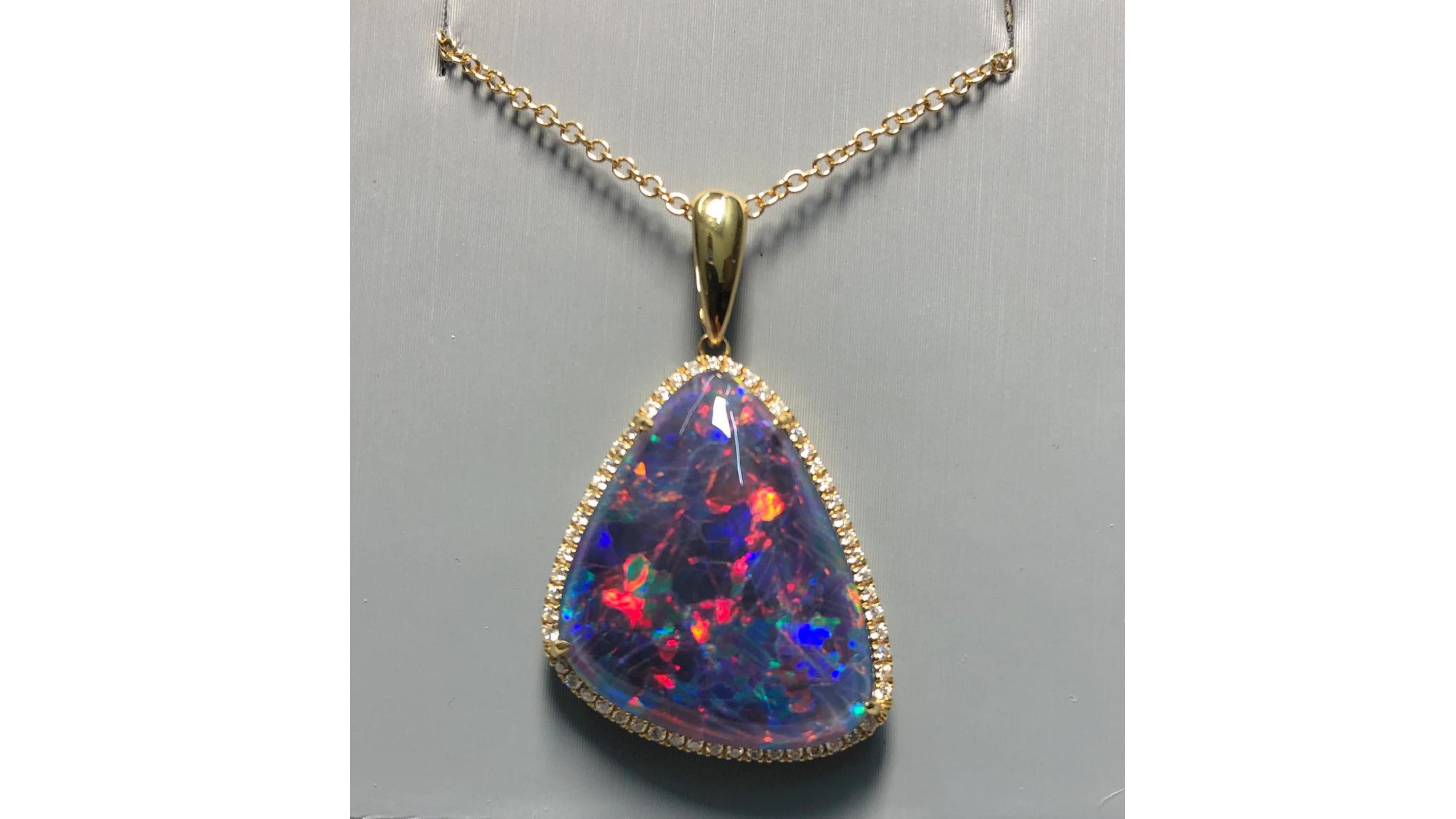 
Black Australian Opal Diamond Necklace 18 Karat White Gold . This is Black Opal shows off very bright colors Blue Yellow Green and plenty of  Red which is a rare find.   With 55 White diamonds it really does add a touch of class and Its from Coober