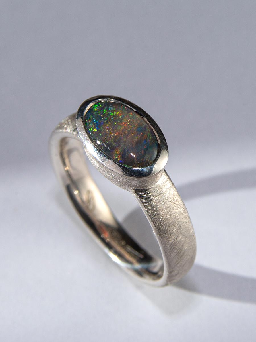 La bague en argent en opale noire d'Australie est un bijou exquis qui met magnifiquement en valeur la splendeur de l'opale naturelle. Avec son jeu de couleurs envoûtant, dont le vert, le rouge, le bleu et le jaune, cette opale est vraiment