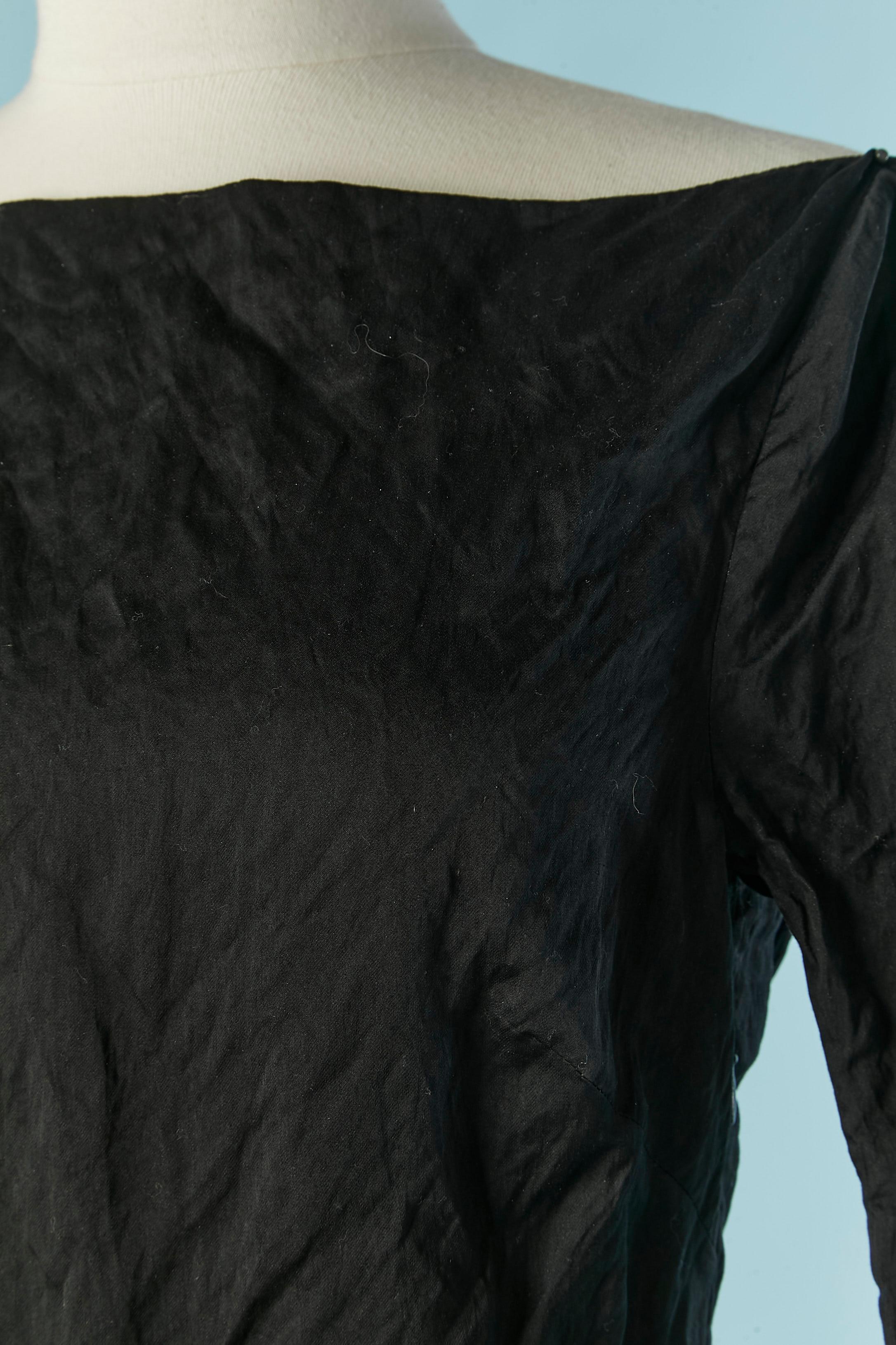 Schwarzes rückenfreies Cocktailkleid aus knitterfreiem Stoff. Keine Stoffzusammensetzung Tag aber wahrscheinlich Baumwolle mit grauem Polyester und Metall Rückseite. Crêpe-Futter nur im oberen Teil des Kleides.
Unsichtbarer Reißverschluss auf der