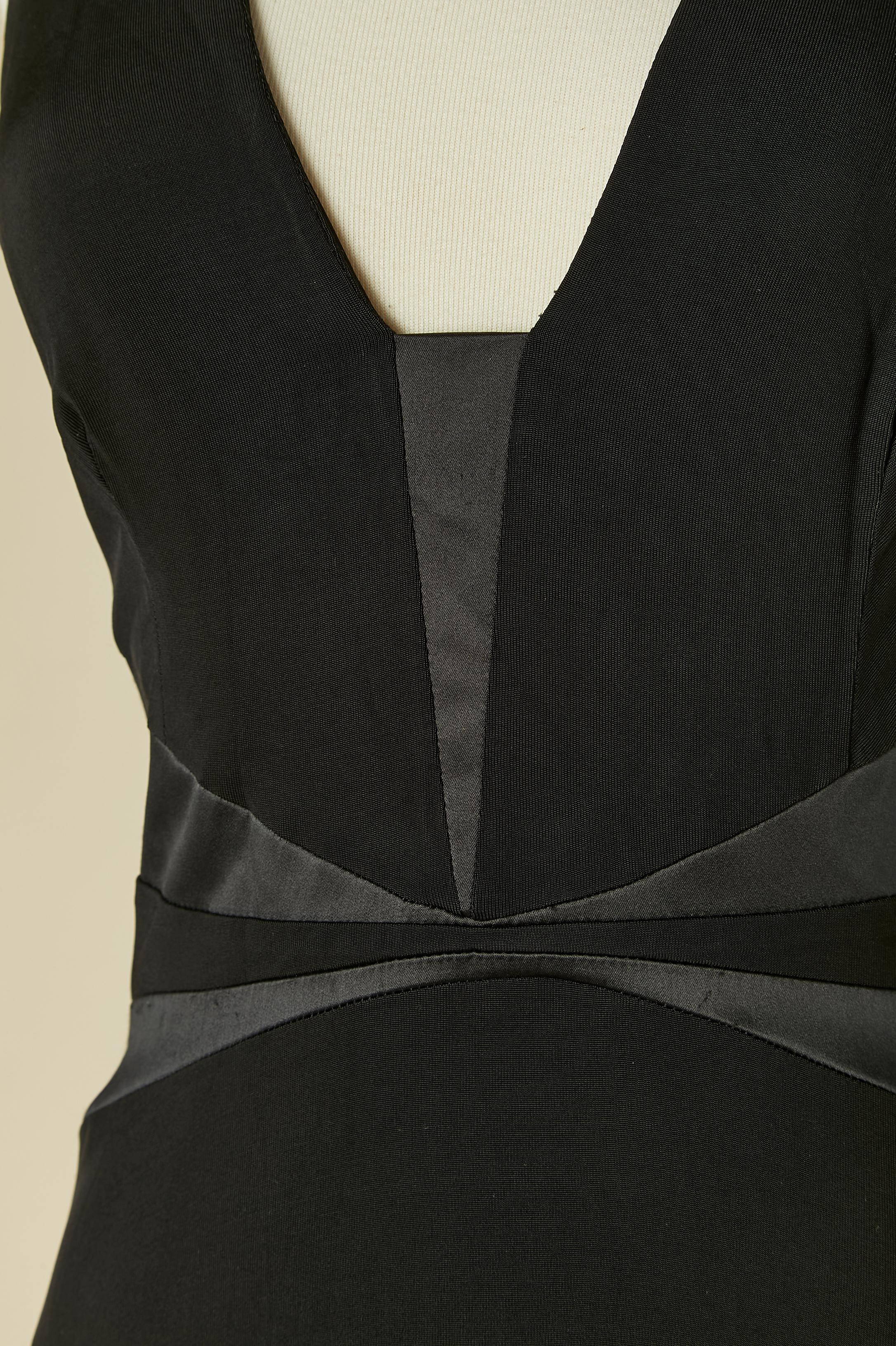 Robe de soirée noire dos nu avec découpes. L'étiquette de la marque a été coupée mais elle est marquée sur la tirette de la fermeture éclair. Pas d'étiquette de composition du tissu non plus mais probablement du satin et de la rayonne. 
Fermeture à