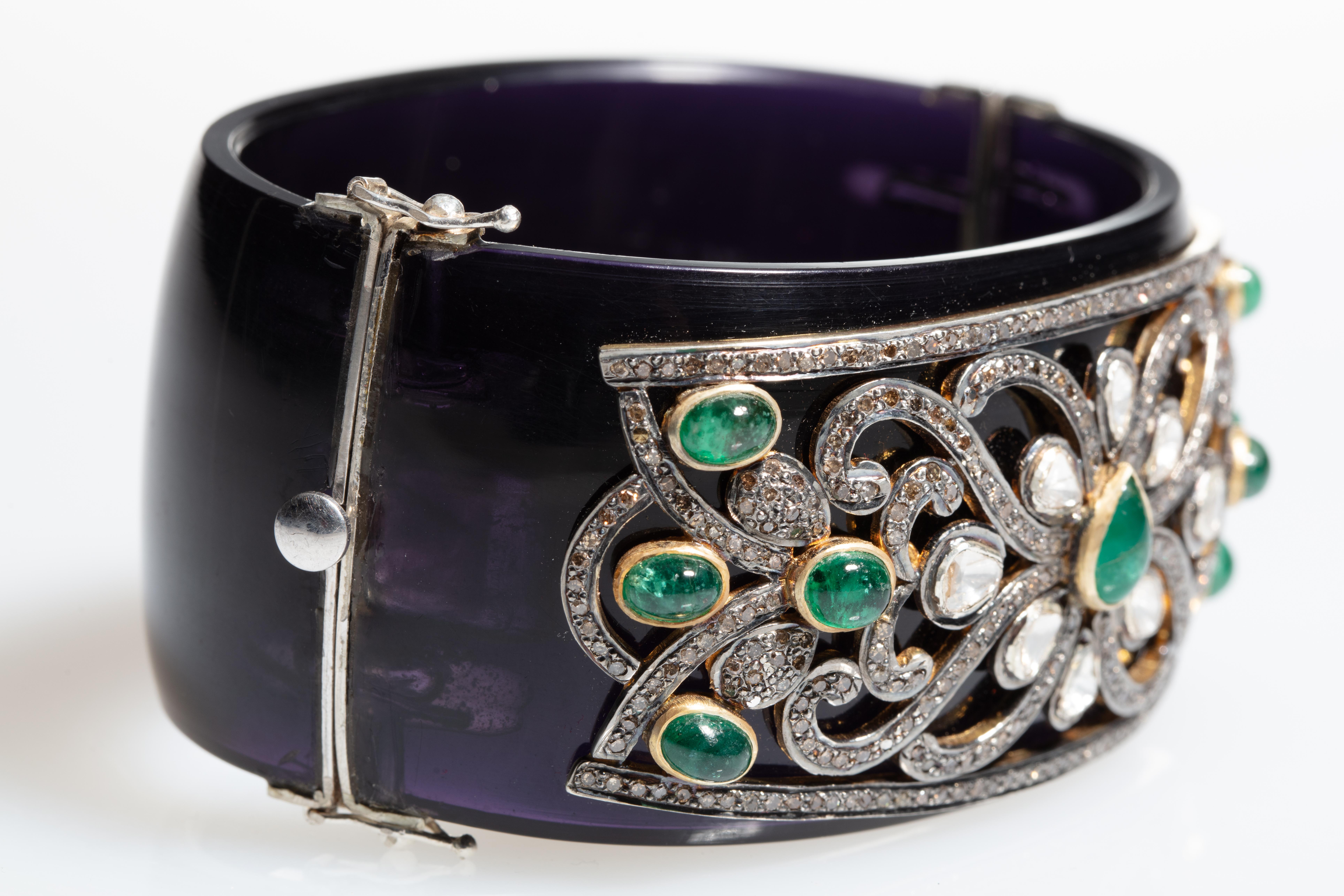 A wide (1.5 inches) cuff bracelet in black Bakelite with rosecut diamonds and brilliant-cut pave`-set diamonds with 8 oval, cabochon emeralds and 1 center, pear-shaped cabochon emerald-- set in sterling silver.  Oval shape keeps the stones sitting