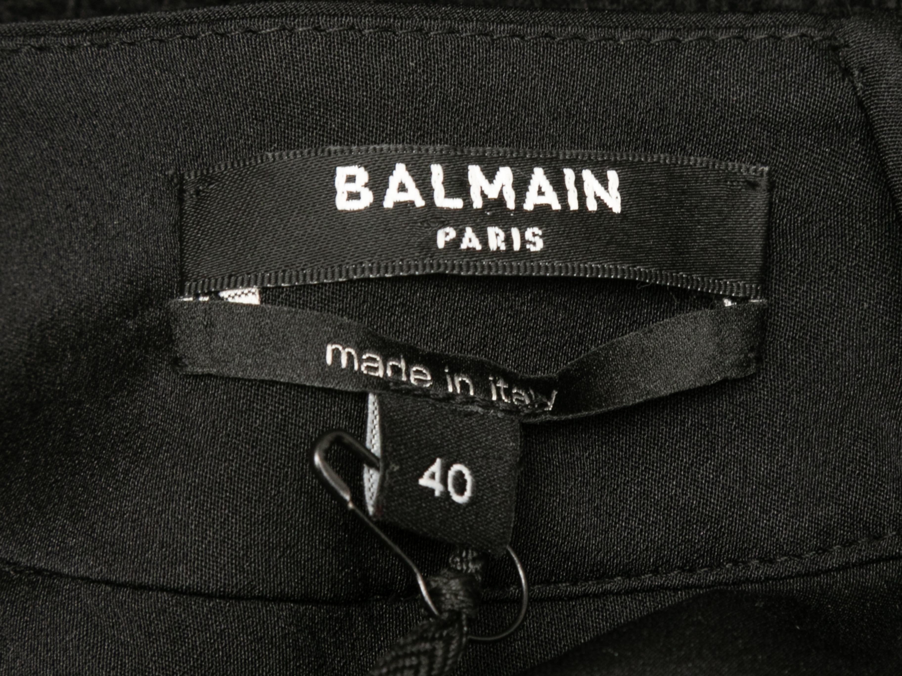 Black sleeveless dress by Balmain. Scoop neckline. Dual welt pockets. Zip closure at back. 34