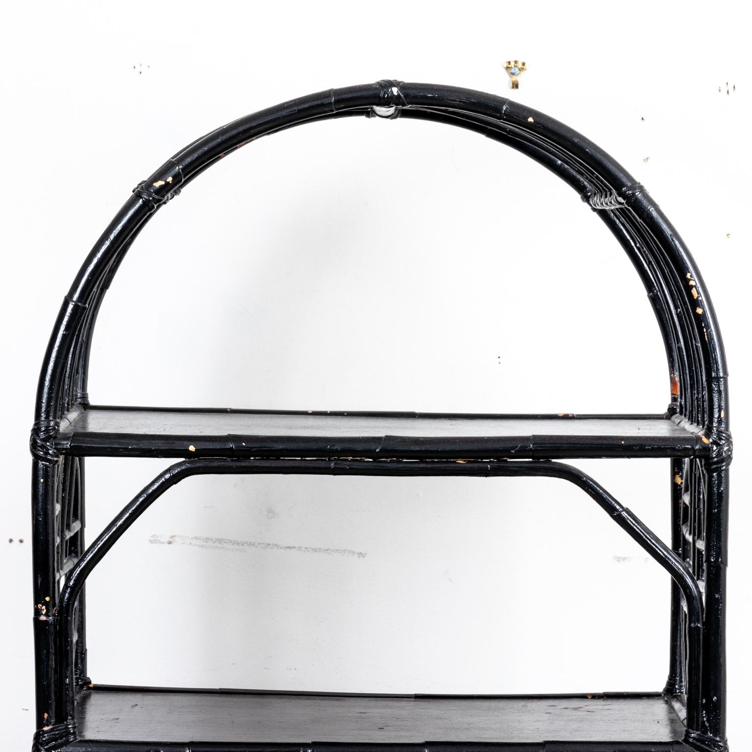 Circa 1870s Hollywood Regency or Chinese Chippendale style black bamboo five tier shelf with a rounded arch frame and geometric Chinoiserie fretwork panels. Please note of war consistent with age including minor chips and paint loss.