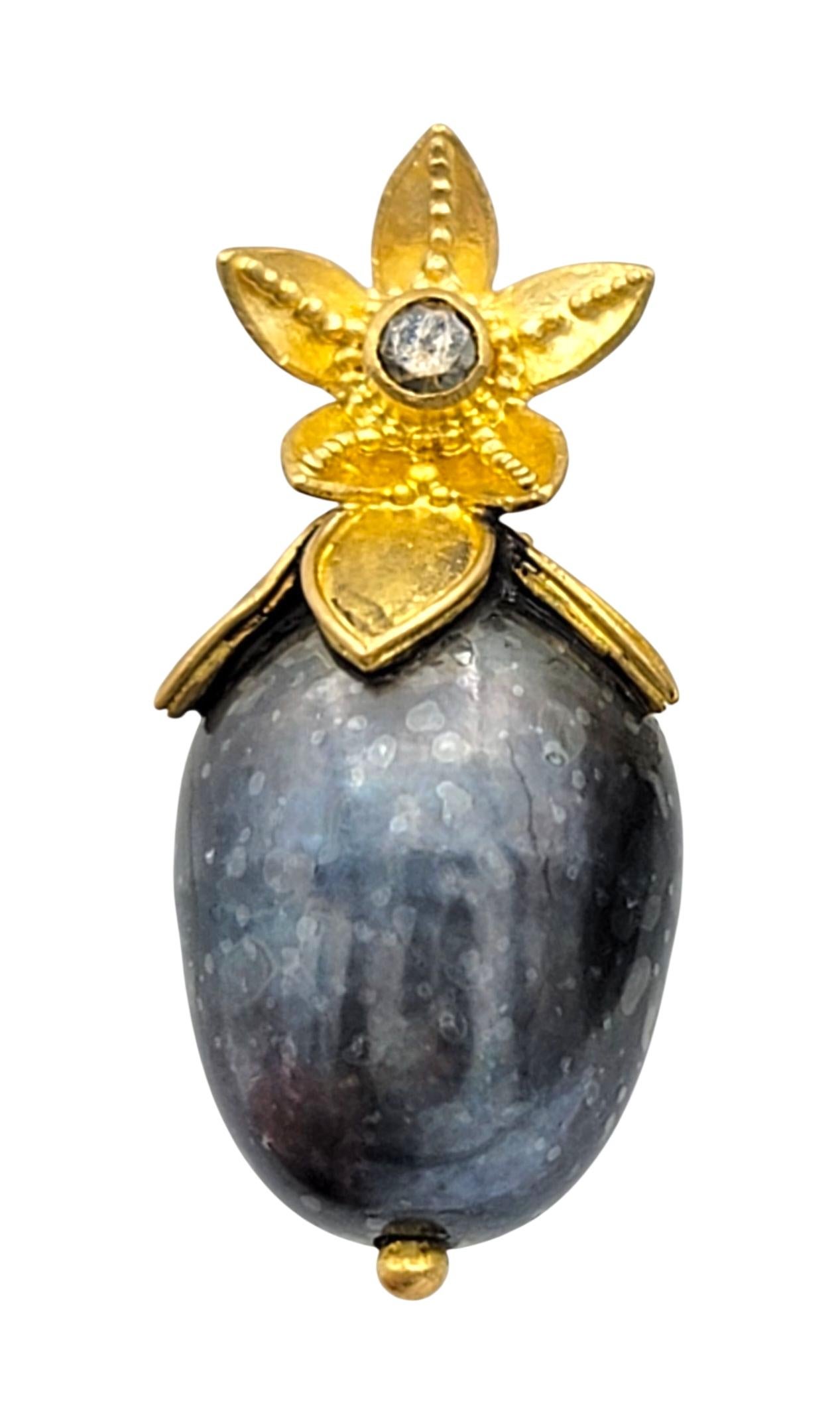 Ces boucles d'oreilles exquises mettent en valeur la beauté naturelle des perles baroques, chacune affichant une riche teinte noire irisée et un lustre captivant. La forme organique des perles leur confère un caractère unique, faisant de chaque