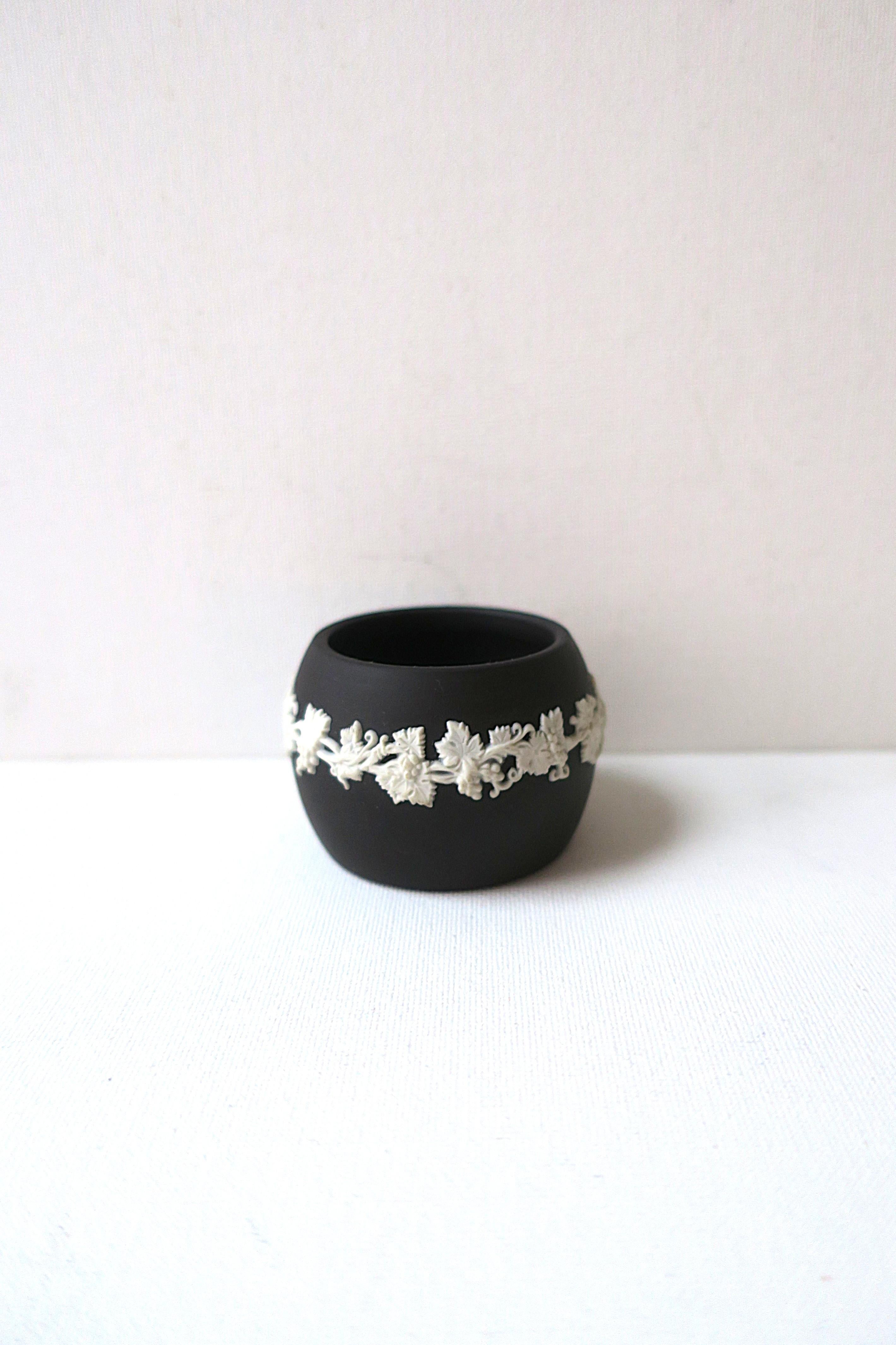 An English basalt Wedgwood vessel in black and white stoneware, circa early to mid-20th century, England. Vessel is black basalt stoneware with applied white jasper neoclassical decoration of grapevines (leaves and grapes) wrapping exterior. This